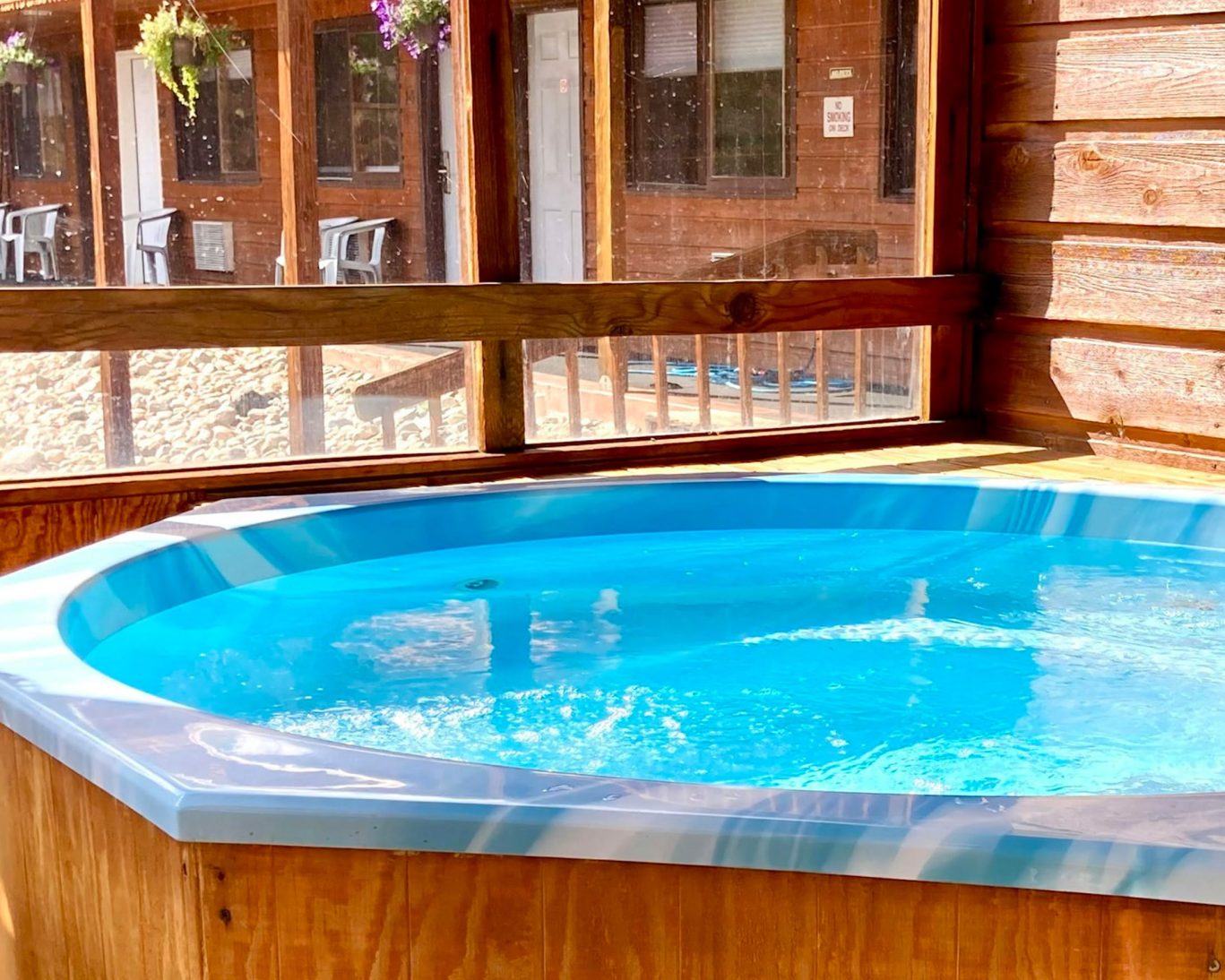 Sunny view of indoor hot tub surrounded by wood paneling at Bighorn Lodge.
