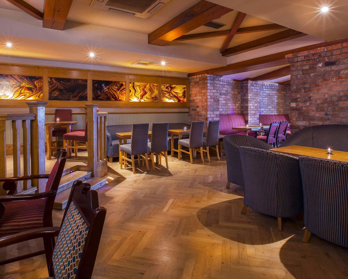 Warm and inviting bar and dining space at The Castle Arch Hotel with brick walls and ambient lighting.