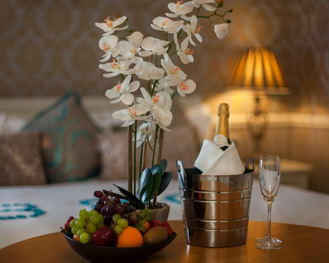 Romantic in-room welcome setup at The Castle Arch Hotel with champagne, orchids, and fresh fruit.