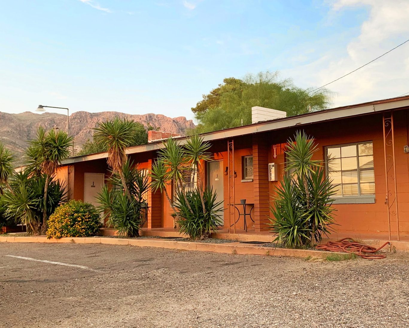 Exterior of Copper Mountain Motel rooms with desert landscaping and mountain views.