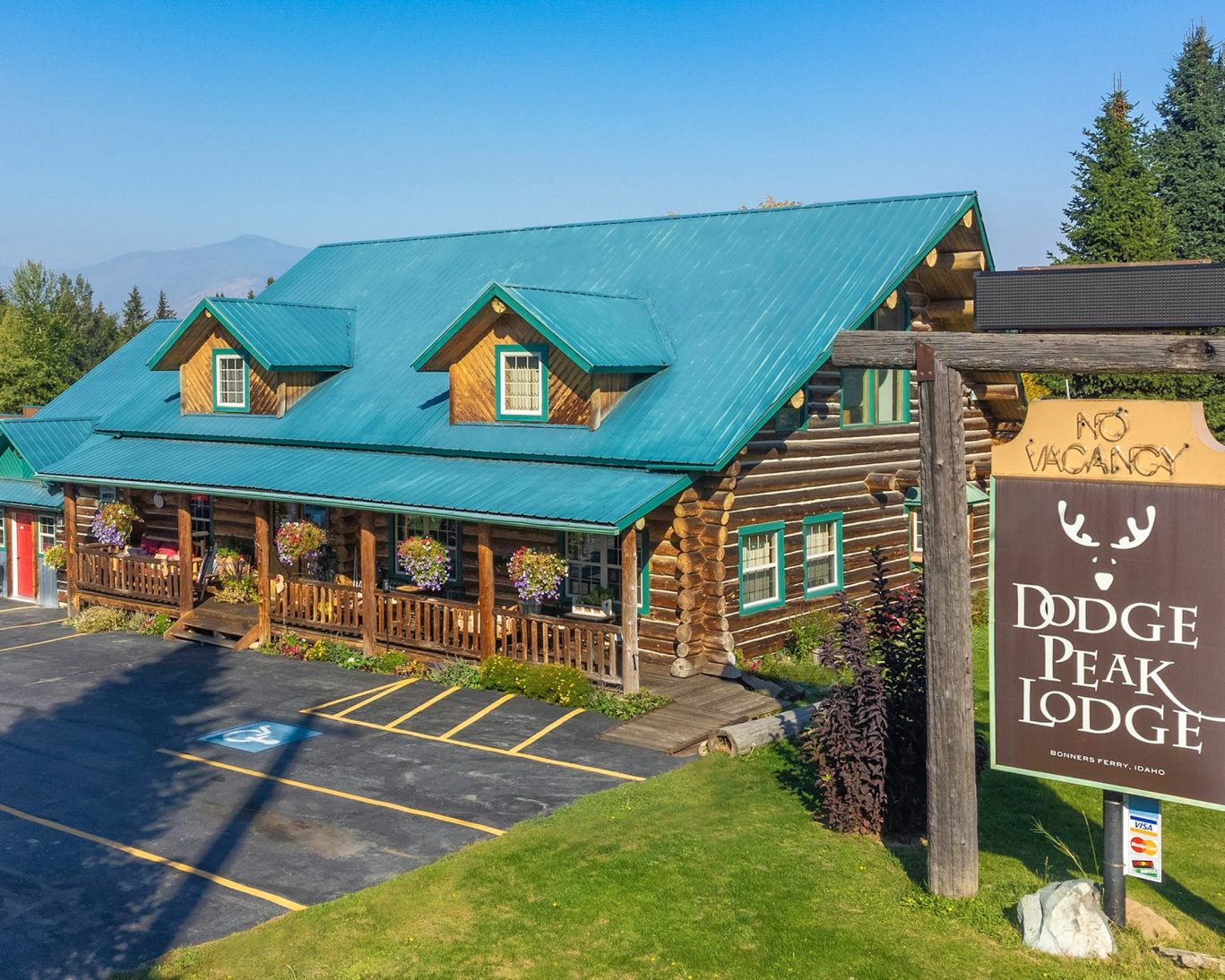 Exterior of Dodge Peak Lodge in Bonners Ferry, Idaho with log cabin design and teal roof.