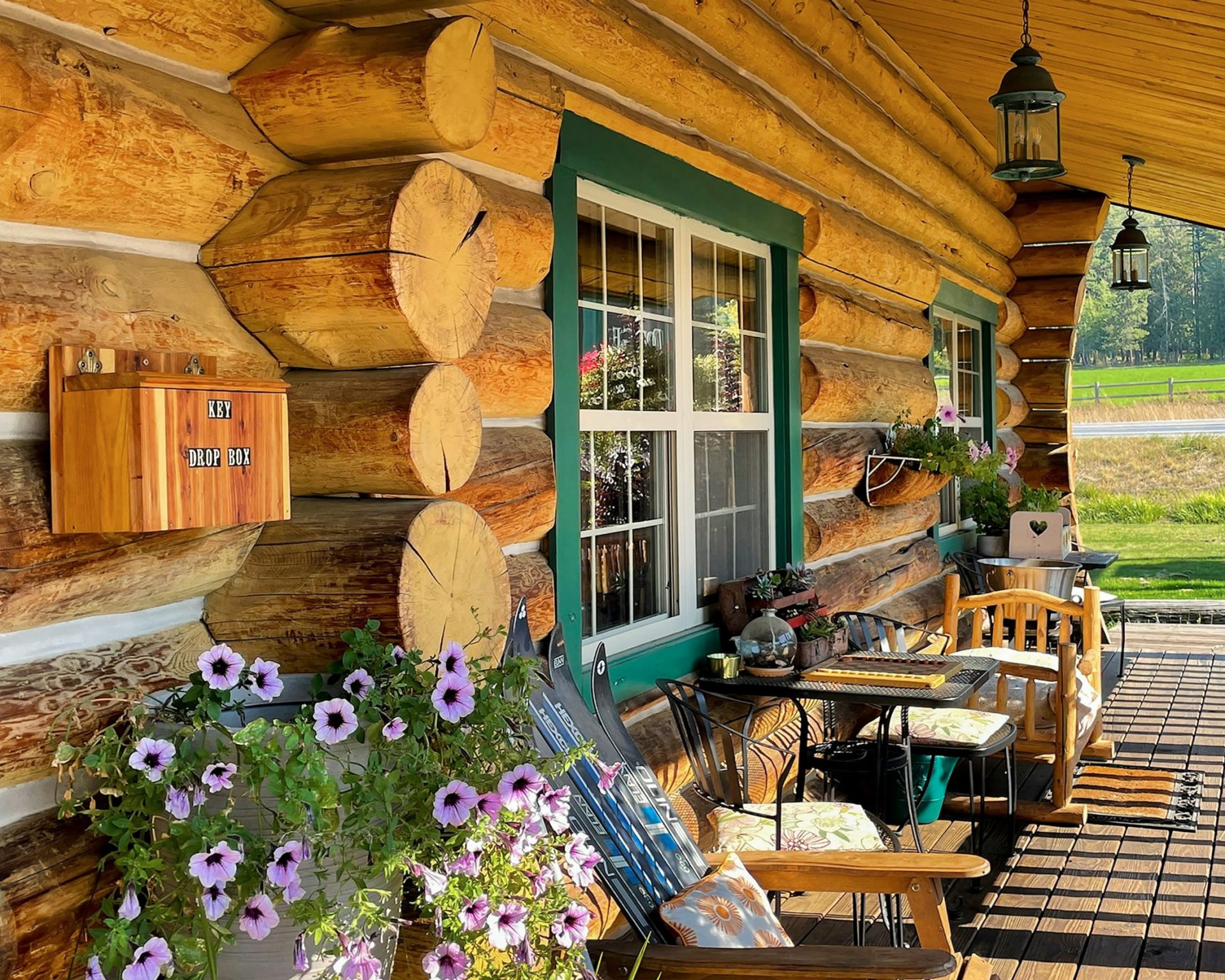 Charming log cabin porch with wooden seating and flower decor at Dodge Peak Lodge.