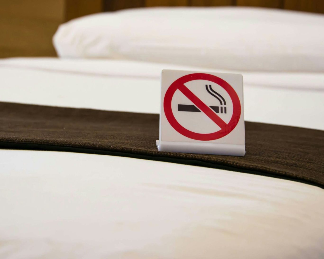 Non-smoking room sign on freshly made bed at Economy Inn Sylmar.