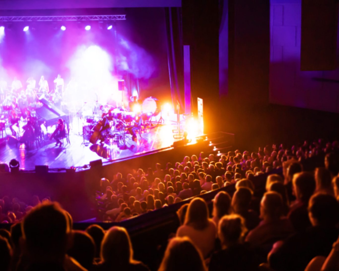 Live performance at the California Center for the Arts Escondido with a full audience and colorful stage lighting.