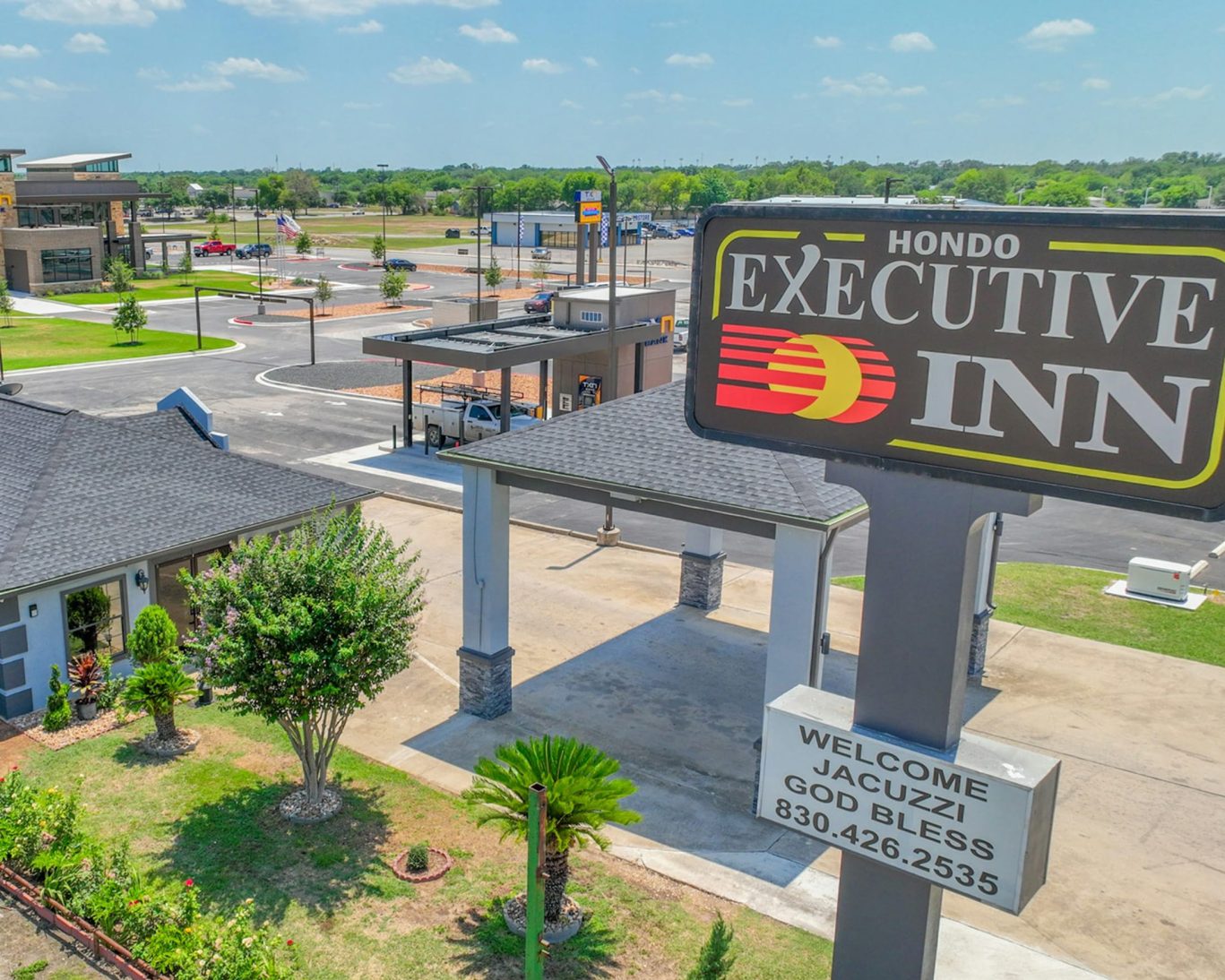 Hondo Executive Inn sign and front entrance with landscaped grounds and convenient location near local businesses.