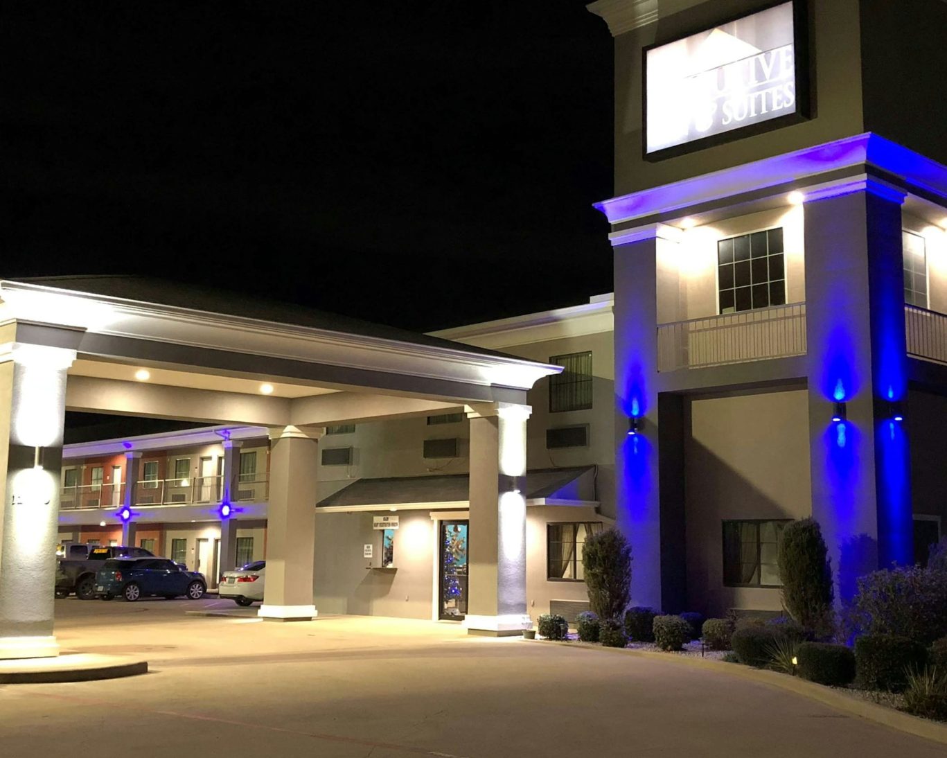 Executive Inn & Suites exterior illuminated at night with welcoming entrance and guest parking.