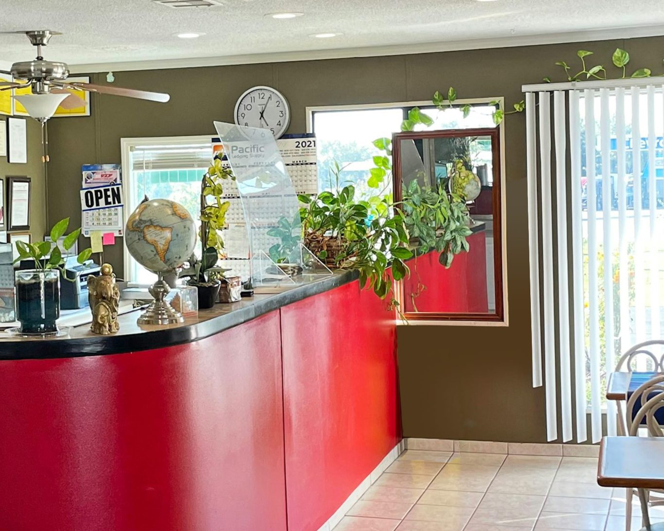 Front desk and check-in area at Express Inn Thomson with red counter and indoor plants.