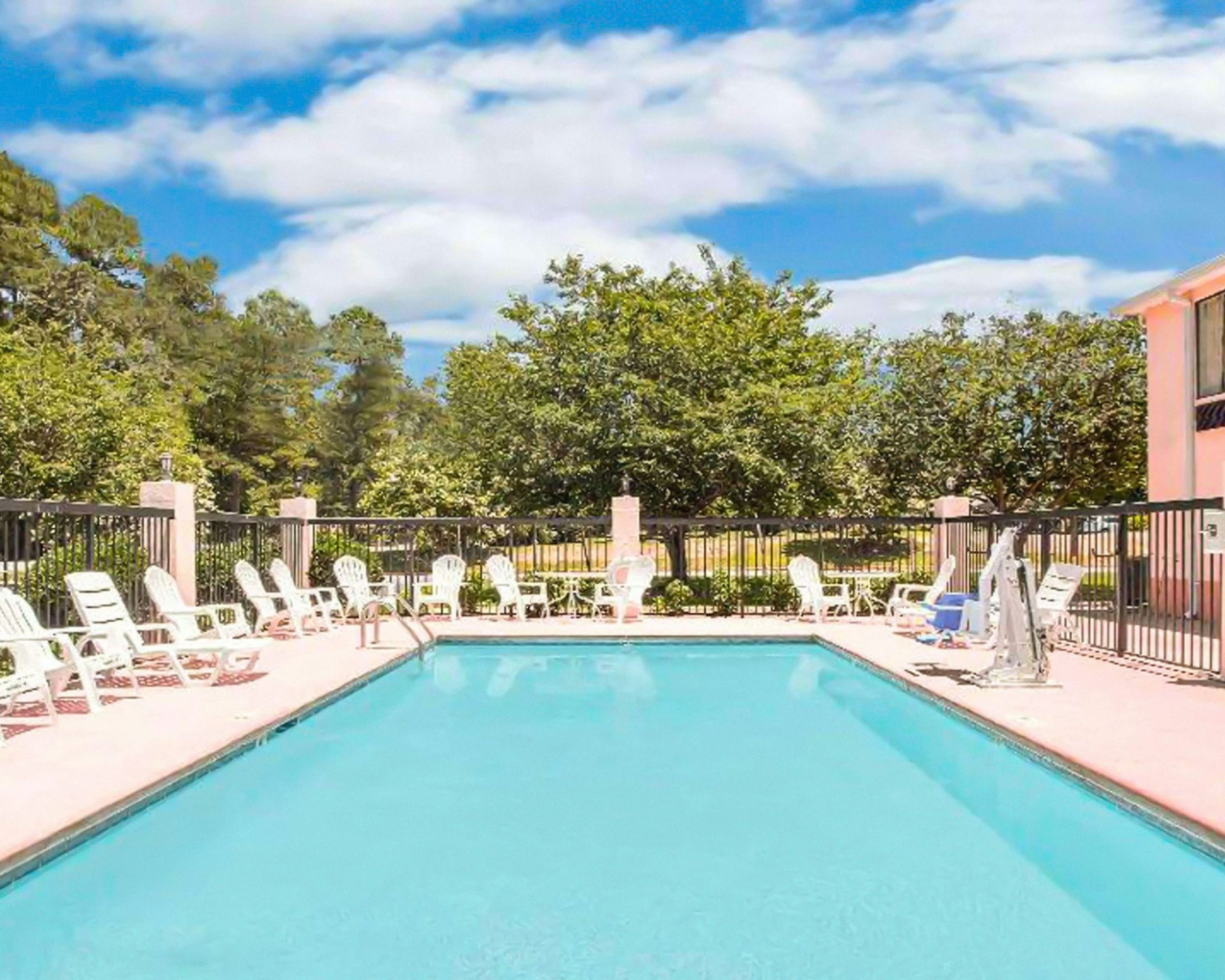 Outdoor swimming pool at Gray Inn surrounded by lounge chairs and greenery.