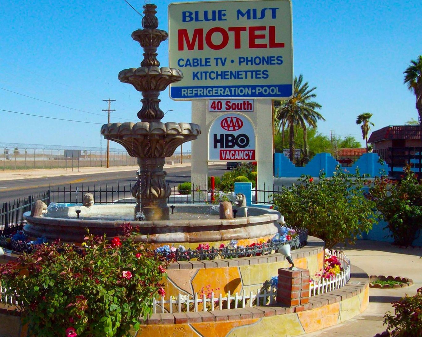 Front fountain and signage at Blue Mist Motel highlighting amenities and AAA rating.