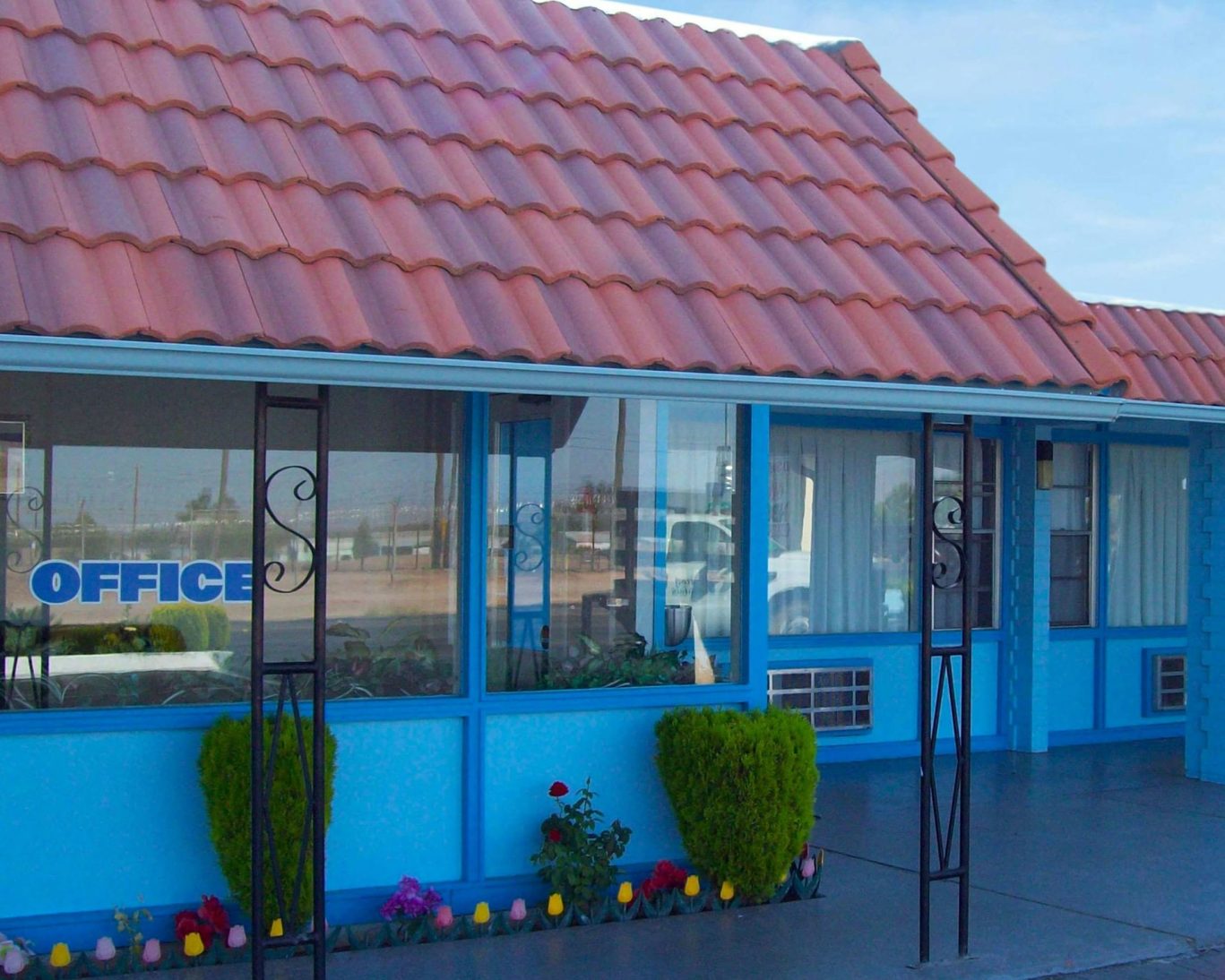 Blue Mist Motel office exterior with red tile roof and well-maintained landscaping.