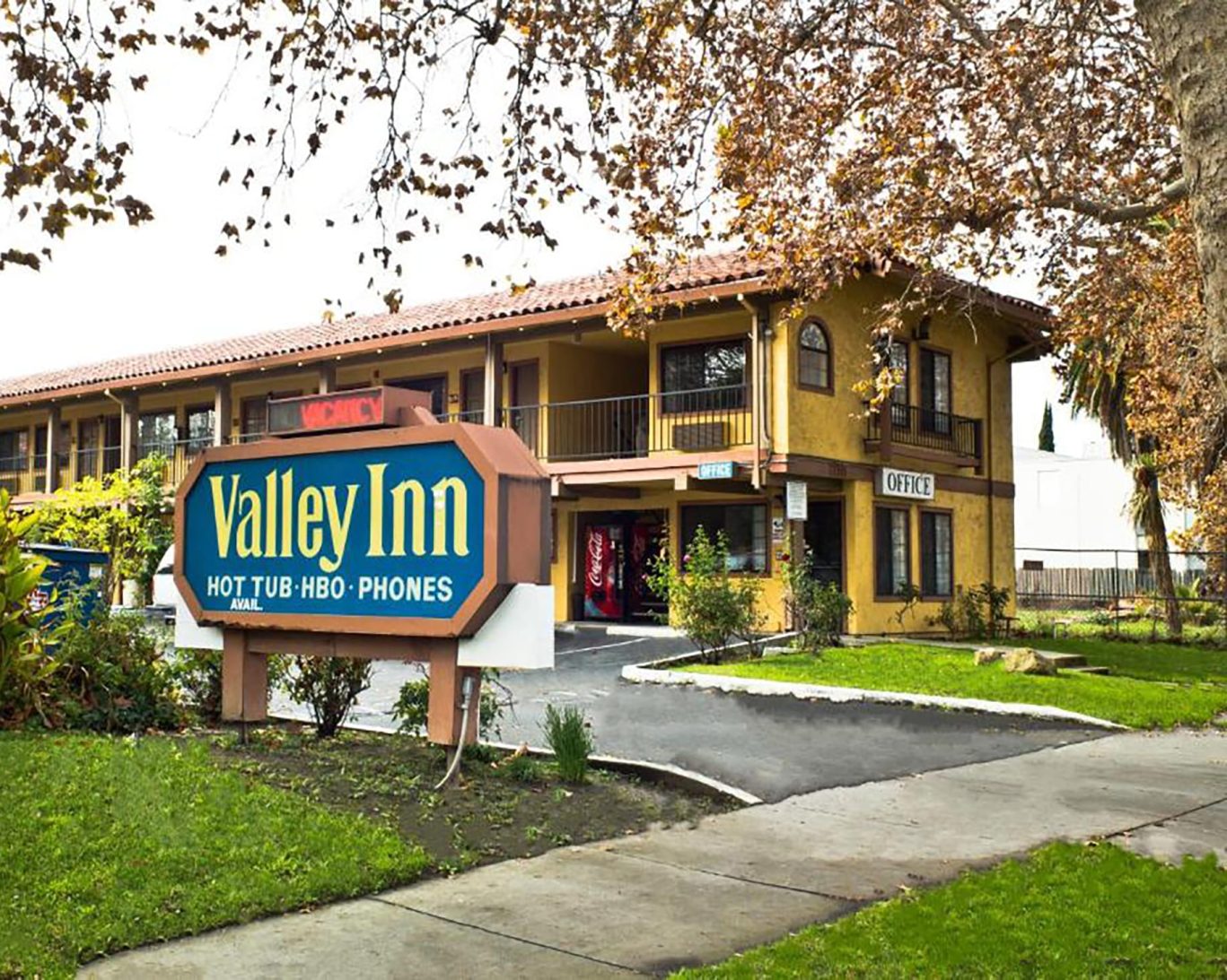 Exterior view of Valley Inn San Jose with visible signage, office entrance, and tree-lined surroundings.