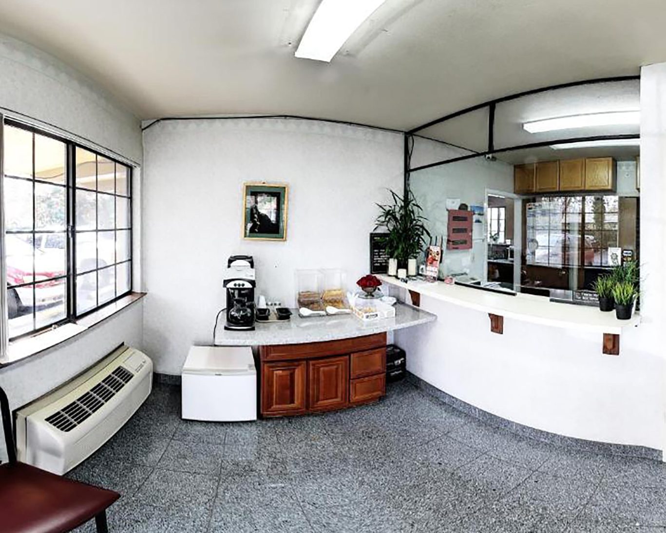 Spacious lobby of Valley Inn San Jose featuring large window, coffee station, and check-in counter