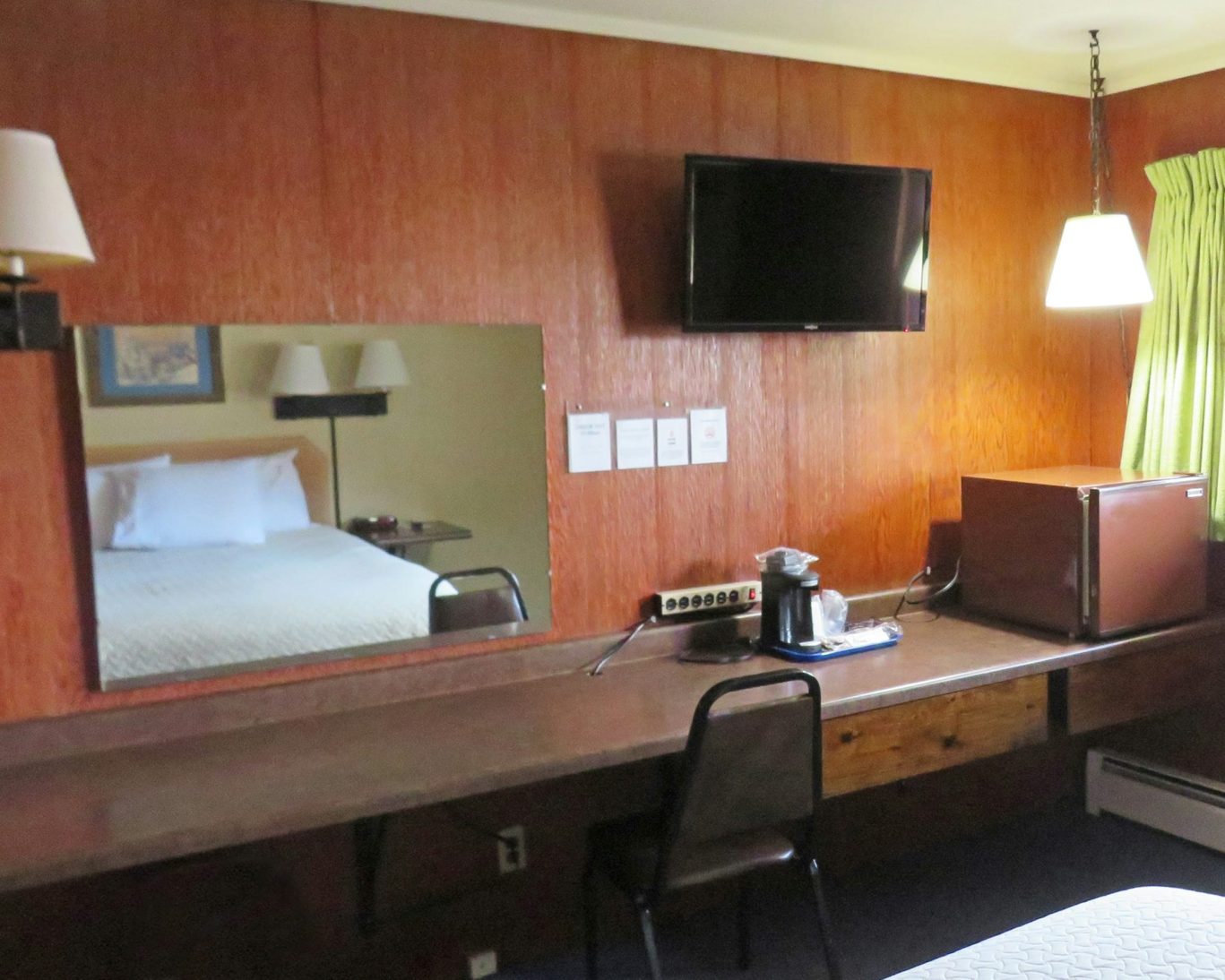 Room at Indianhead Motel with workspace, microwave, mini-fridge, flat-screen TV, and coffee maker.