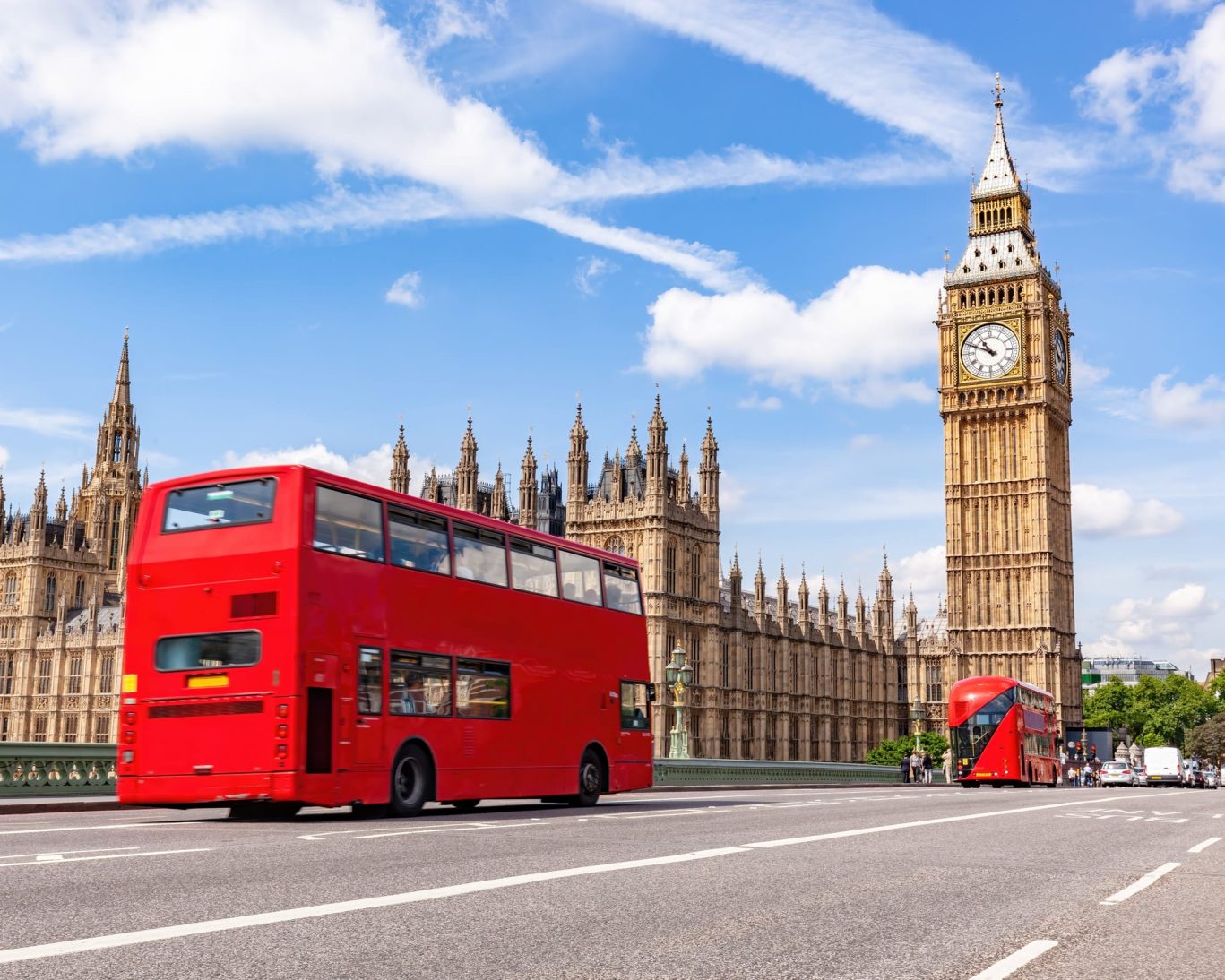 Red double-decker buses crossing Westminster Bridge with Big Ben and Houses of Parliament in the background.