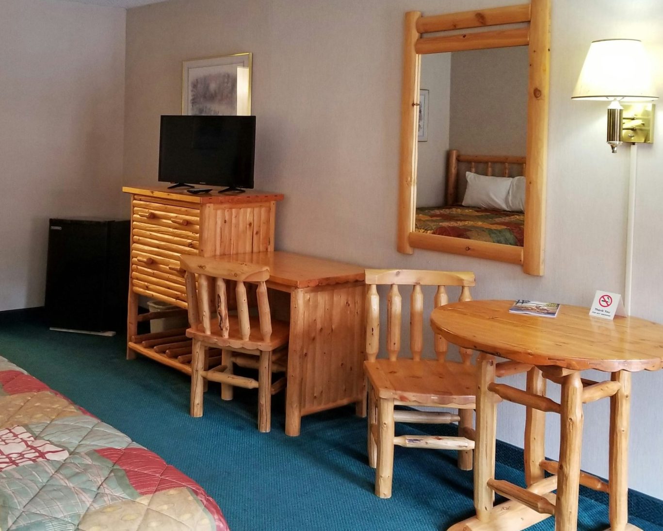 Rustic guest room at Keystone hotel featuring log furniture, flat-screen TV, and writing desk.