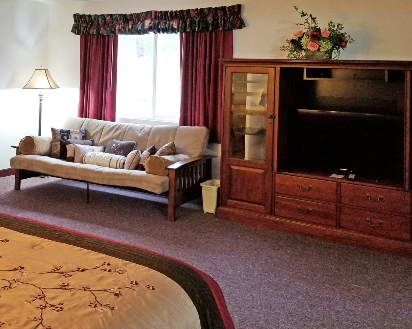 Spacious hotel suite in Keystone with comfortable futon, entertainment center, and floral décor.