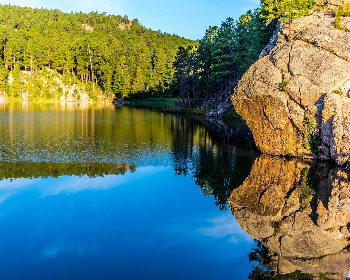 Scenic view of Horse Thief Lake reflecting forest and rock formations in the Black Hills of South Dakota.