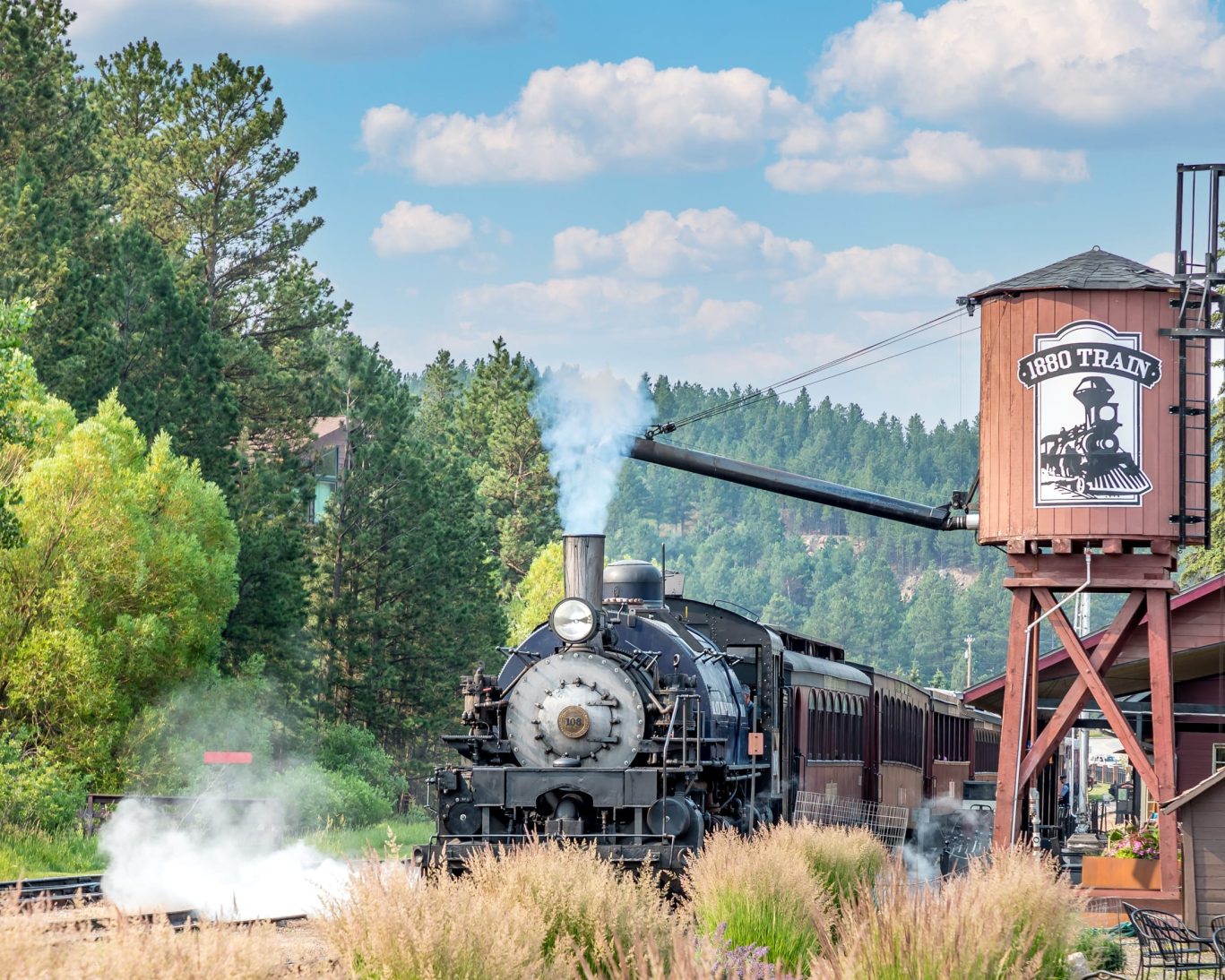 Historic 1880 Train departing from Keystone, South Dakota surrounded by Black Hills pine forest.