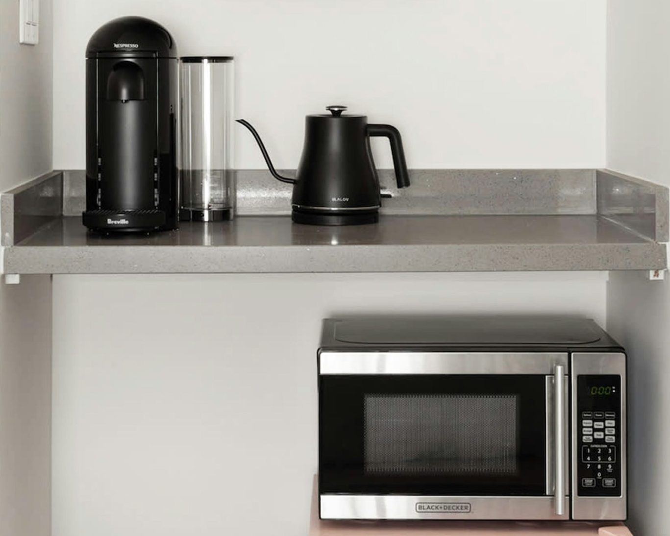 In-room coffee and tea station featuring Nespresso machine, electric kettle, and microwave.