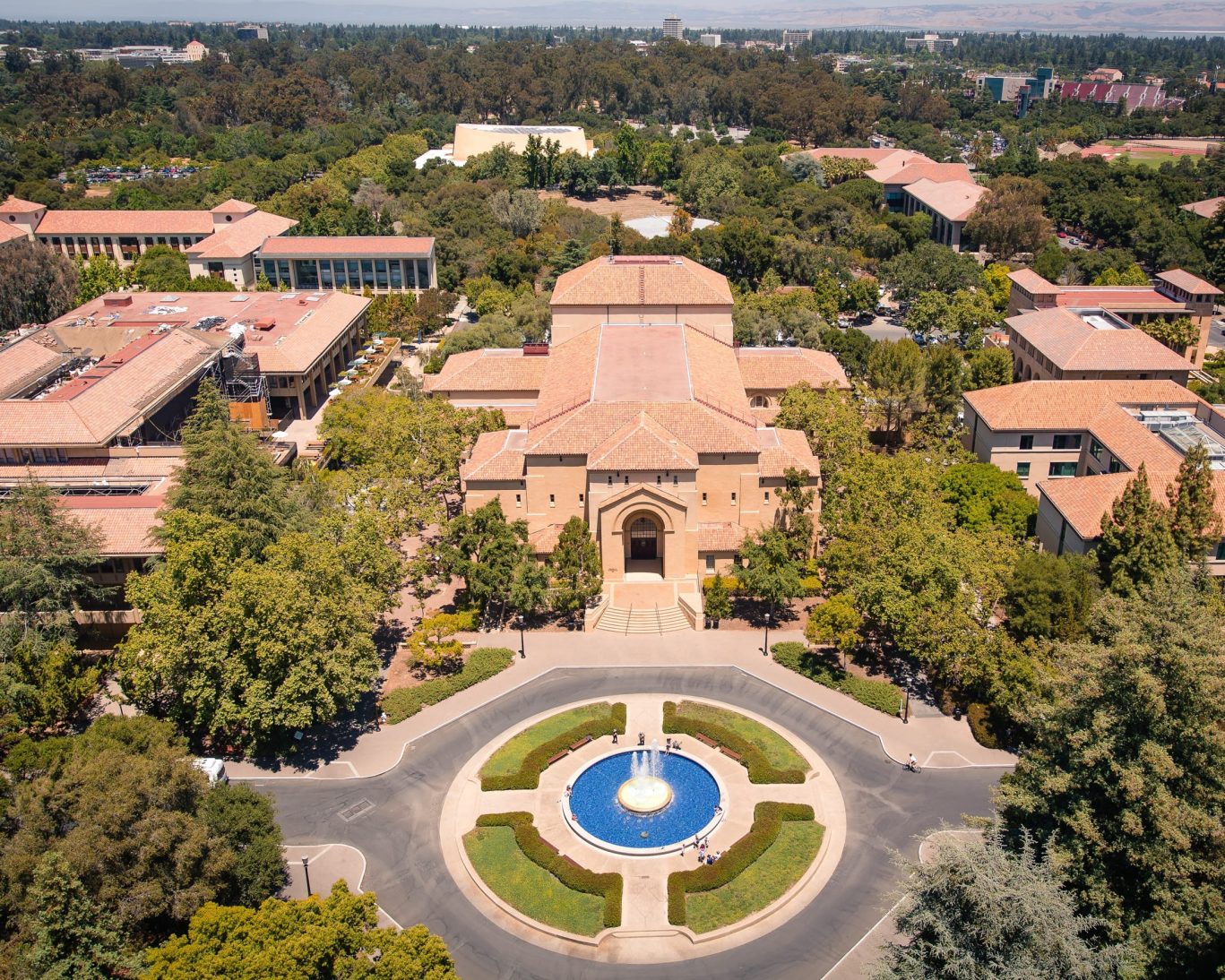 Aerial view of Stanford University campus with central fountain and historic buildings.