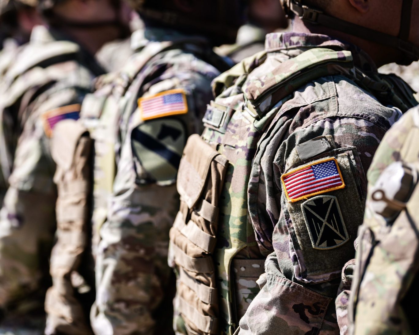 Close-up of U.S. Army soldiers in camouflage uniforms standing in formation at Fort Carson military base.
