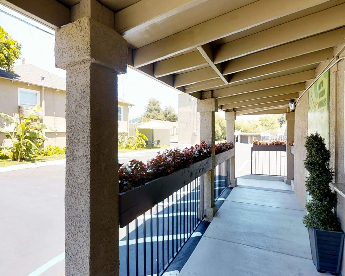 Covered walkway with flower boxes leading to the entrance of Discovery Inn in Napa, California.