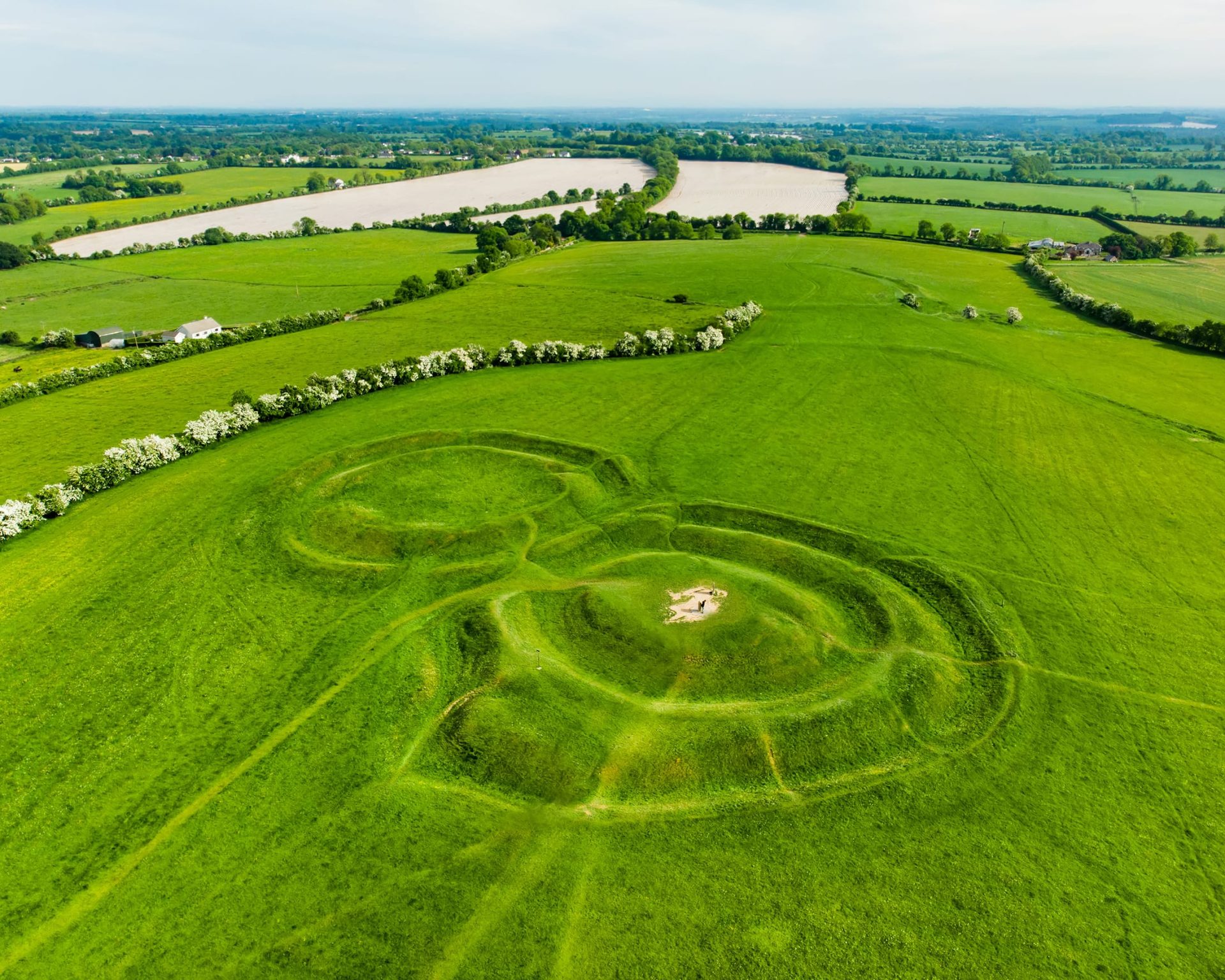 Drone view of the Hill of Tara, ancient ceremonial site with ring fort structures in County Meath, Ireland.