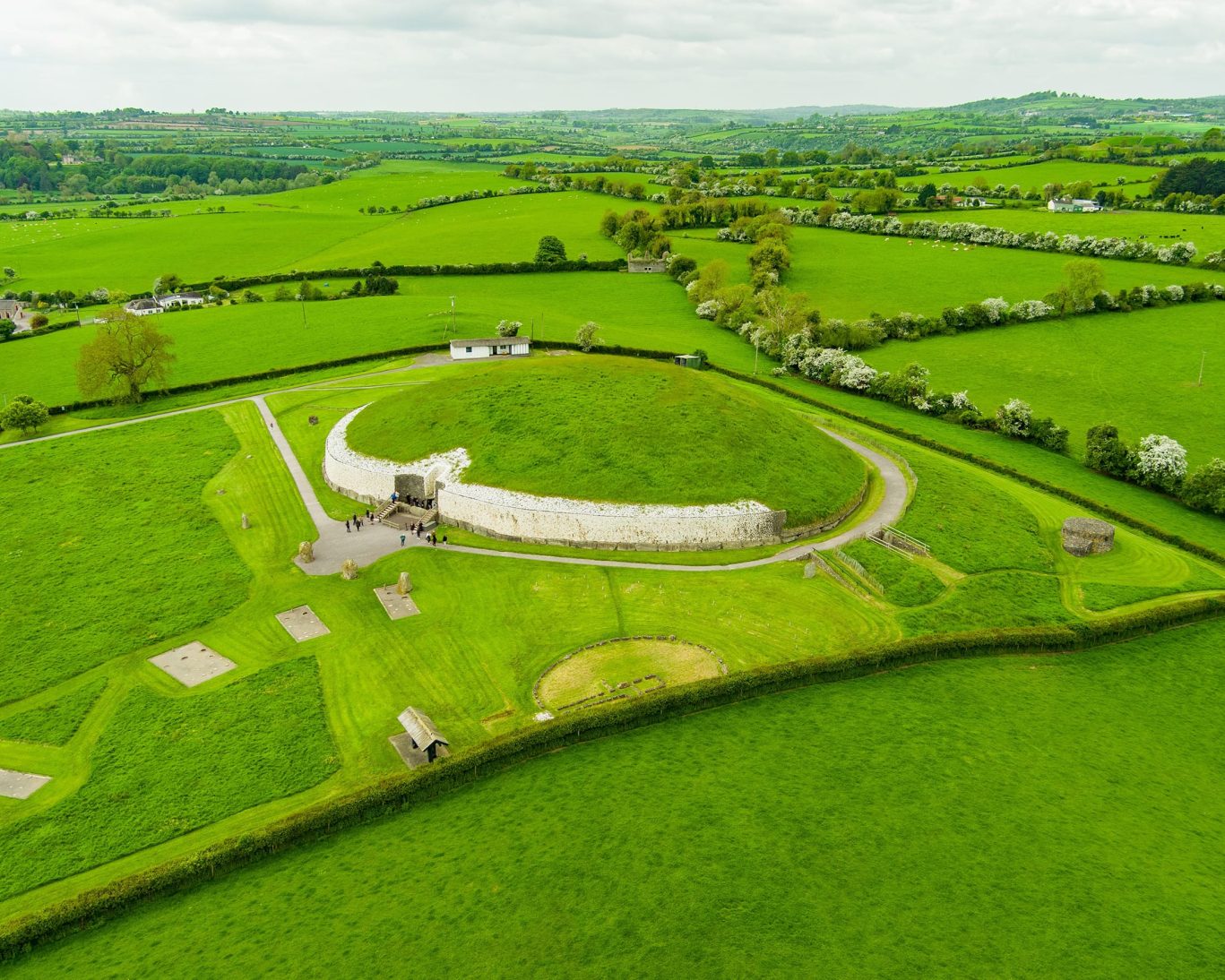 UNESCO World Heritage Site Newgrange passage tomb in Ireland’s Boyne Valley with stone facade and green mound.