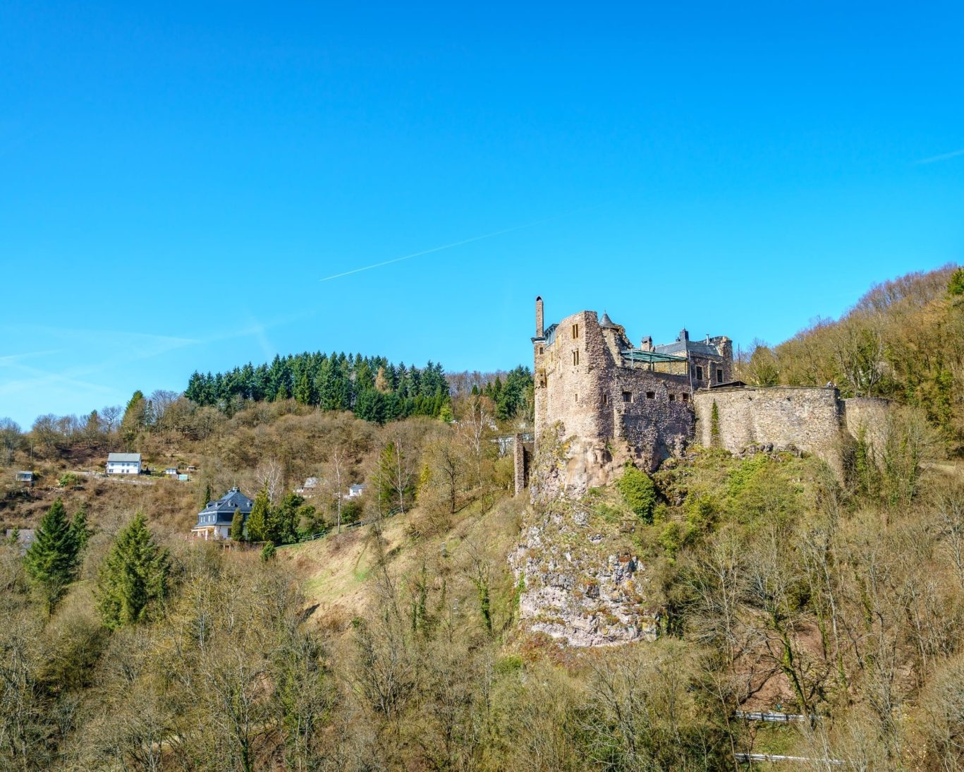 Scenic view of Schloss Oberstein castle ruins atop a hill in Idar-Oberstein, Germany on a clear day.