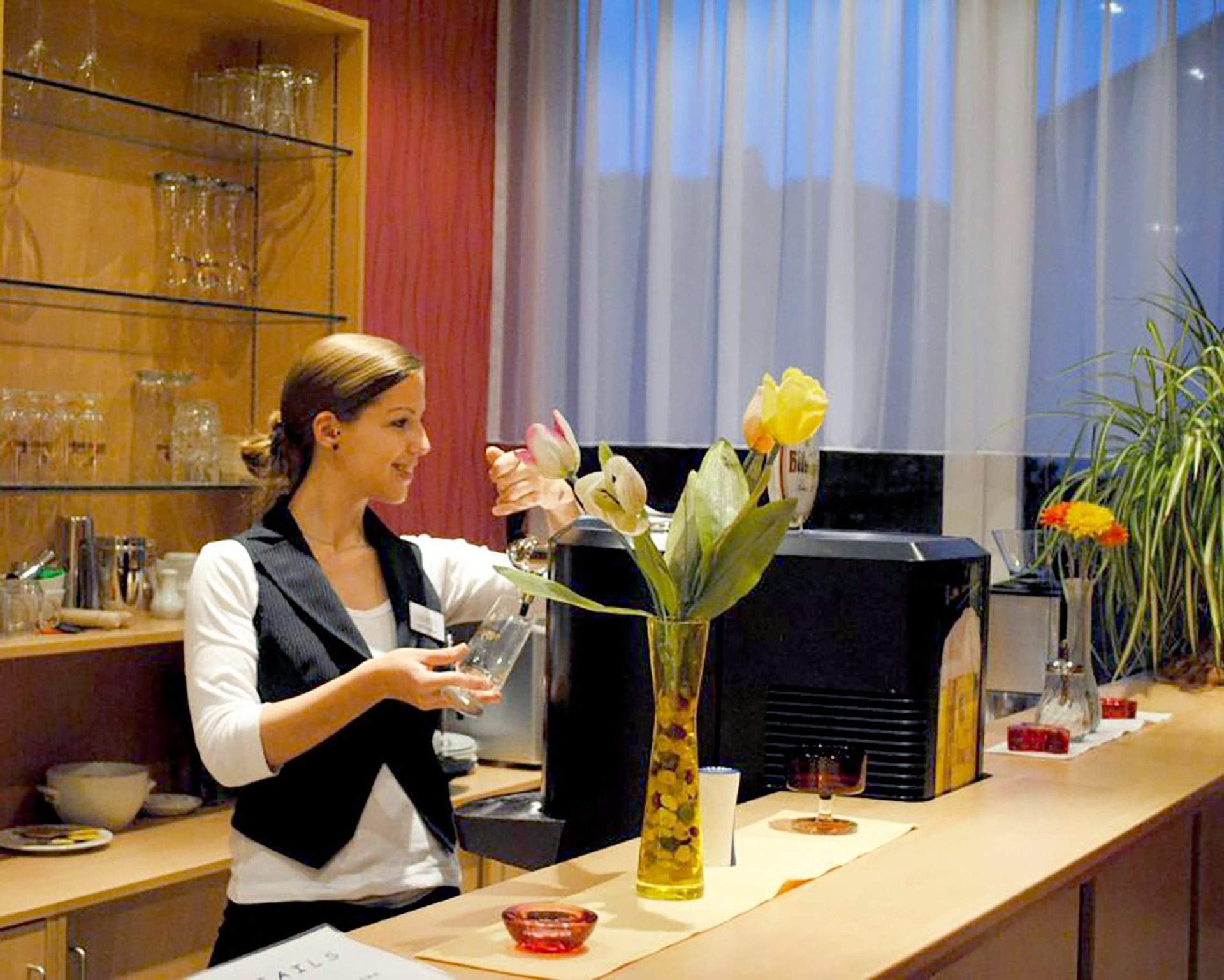 Smiling hotel staff preparing drinks at the Opal Hotel bar in Bad Kreuznach, Germany.