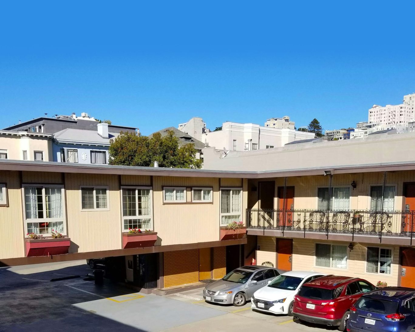 Exterior view of Pacific Heights Inn San Francisco with on-site parking and city backdrop.
