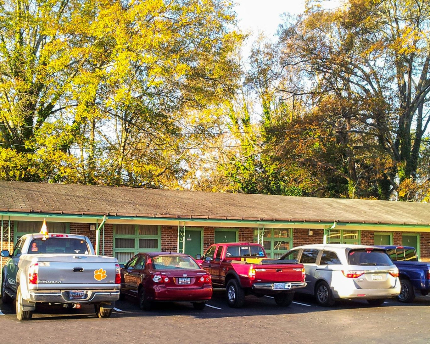 Guest parking area at Relax Inn Westminster with cars outside motel rooms.