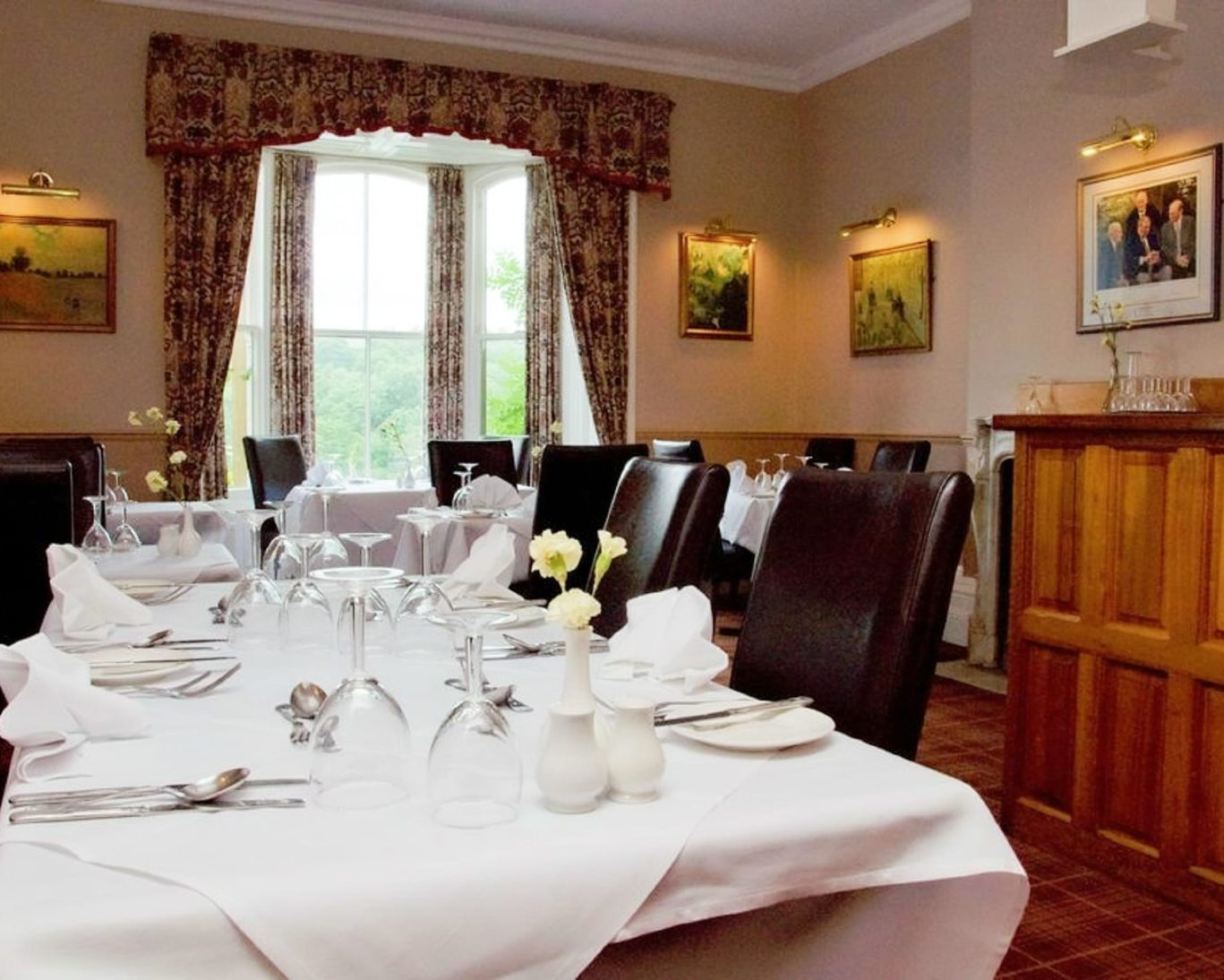 Elegant dining room at Riverdale Hall Hotel with white tablecloths and garden view.