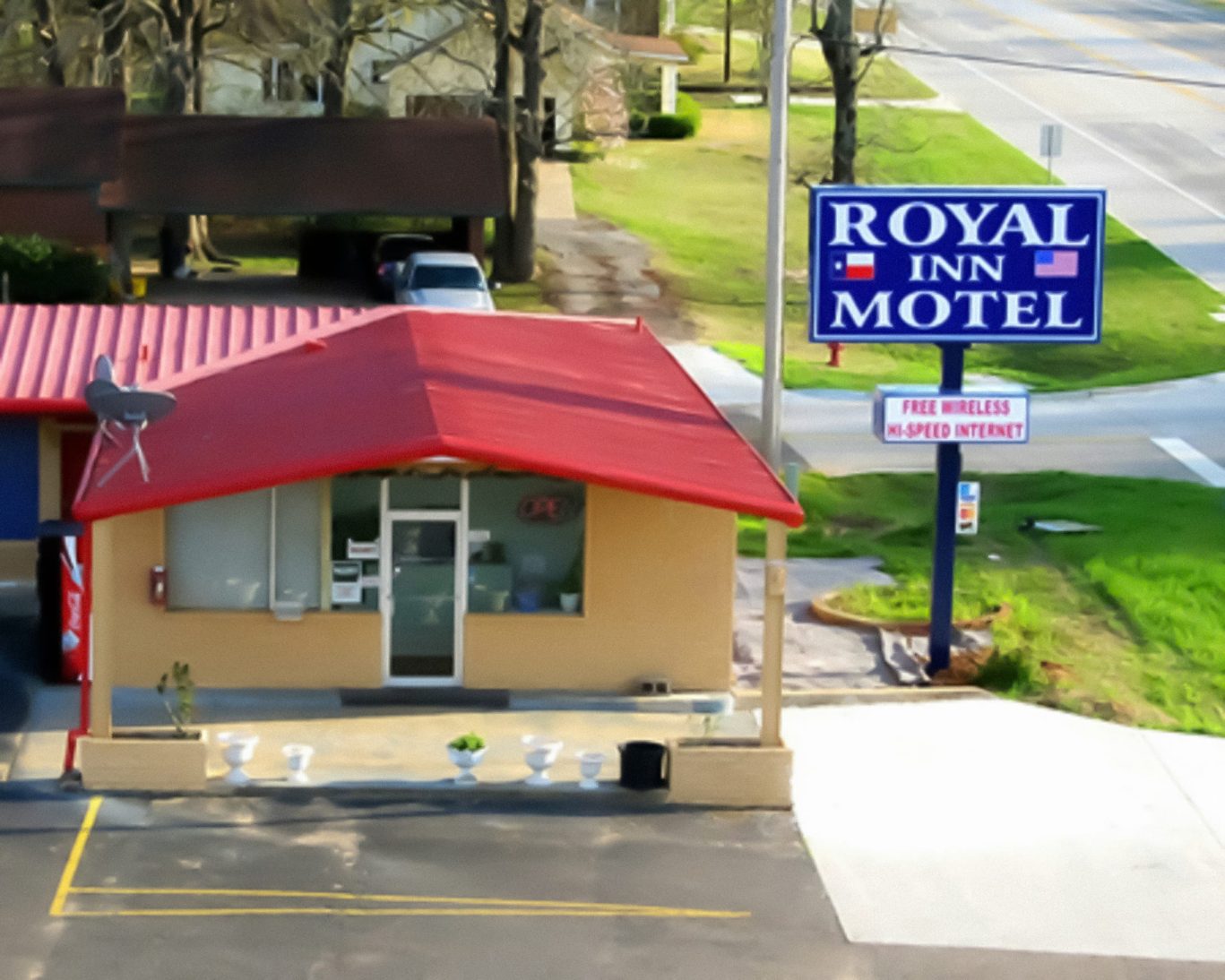 Exterior of Royal Inn Motel in Linden with red roof and roadside sign offering free Wi-Fi.