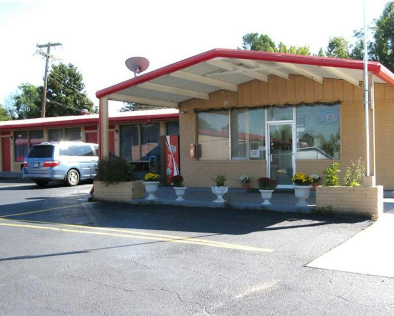 Front office of Royal Inn Motel with guest parking and red trim building facade.
