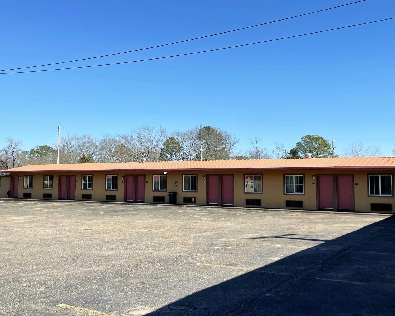 Row of exterior-entry guest rooms at Royal Inn Motel with ample on-site parking.