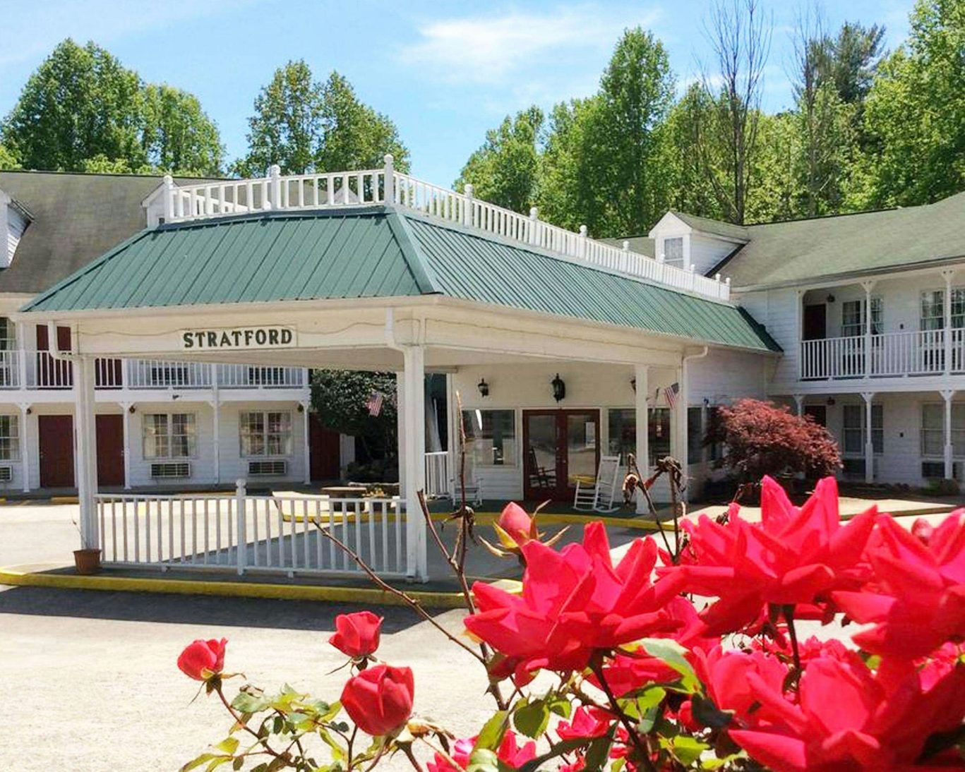 Front entrance of Stratford Motor Inn East Ellijay with red flowers and Southern-style architecture.