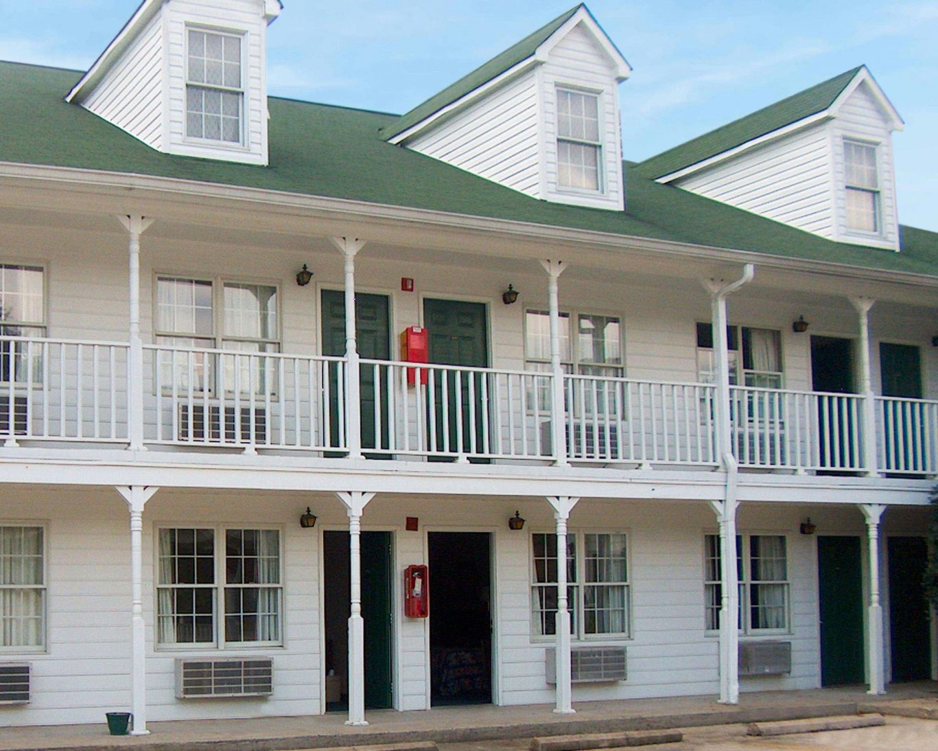 Two-story guest rooms with green doors and white balcony railings at Stratford Motor Inn East Ellijay.