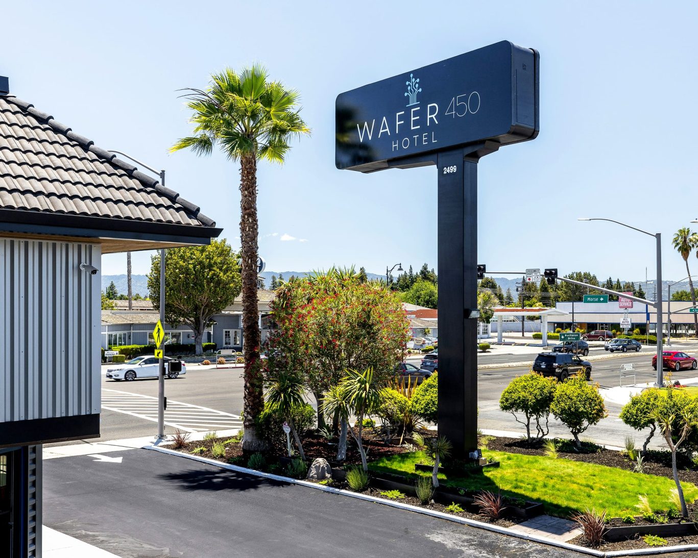 Tall black Wafer 450 Hotel sign on street corner in sunny San Jose, California.