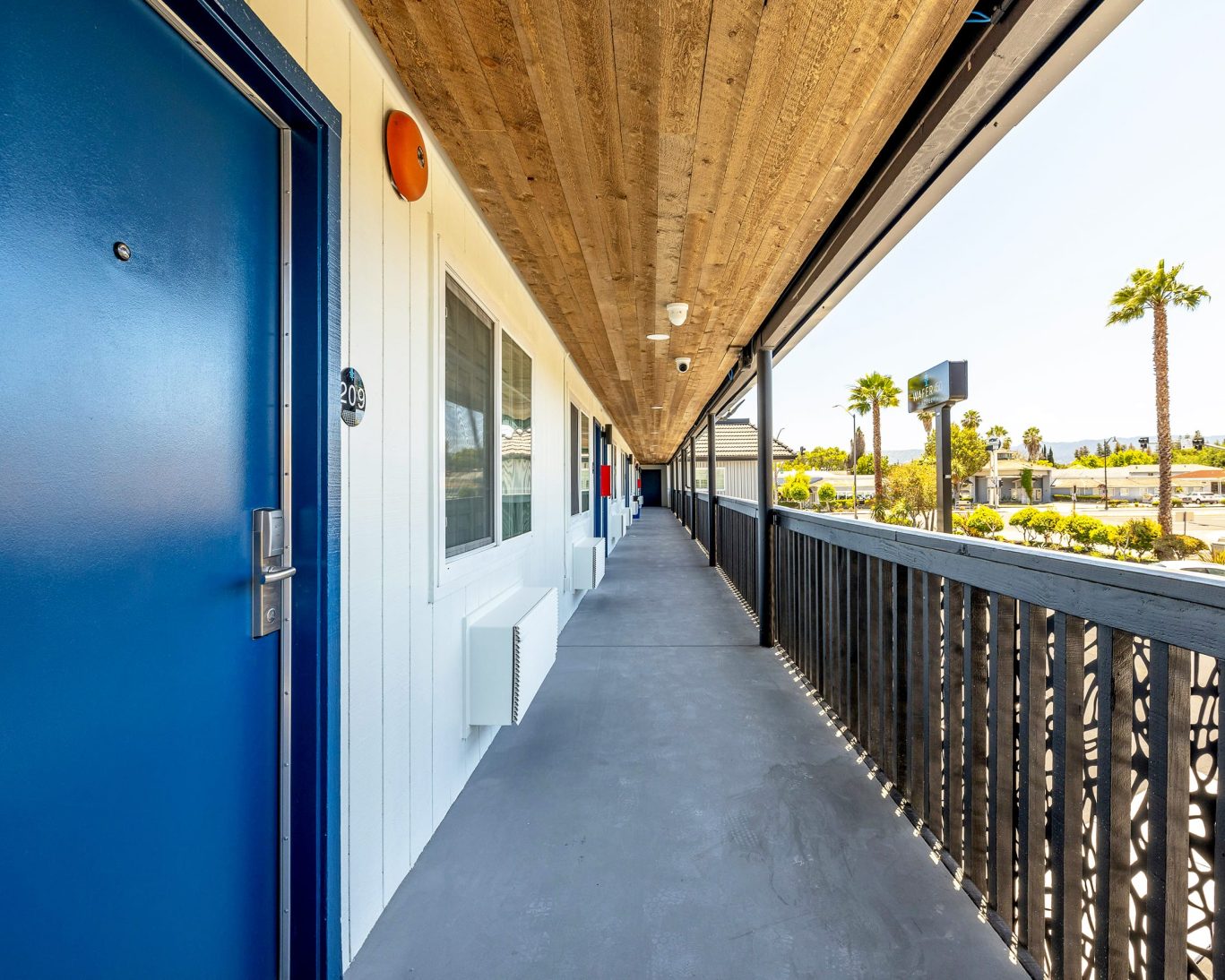 Second-floor guest room entrance and balcony walkway at Wafer 450 Hotel.