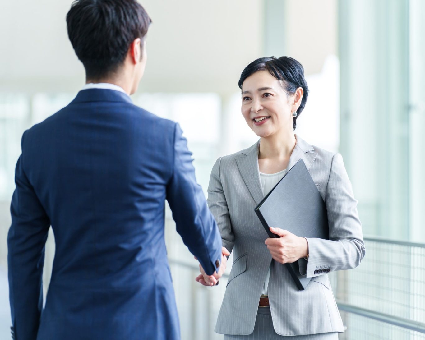 Business professionals shaking hands inside the San Jose Convention Center.