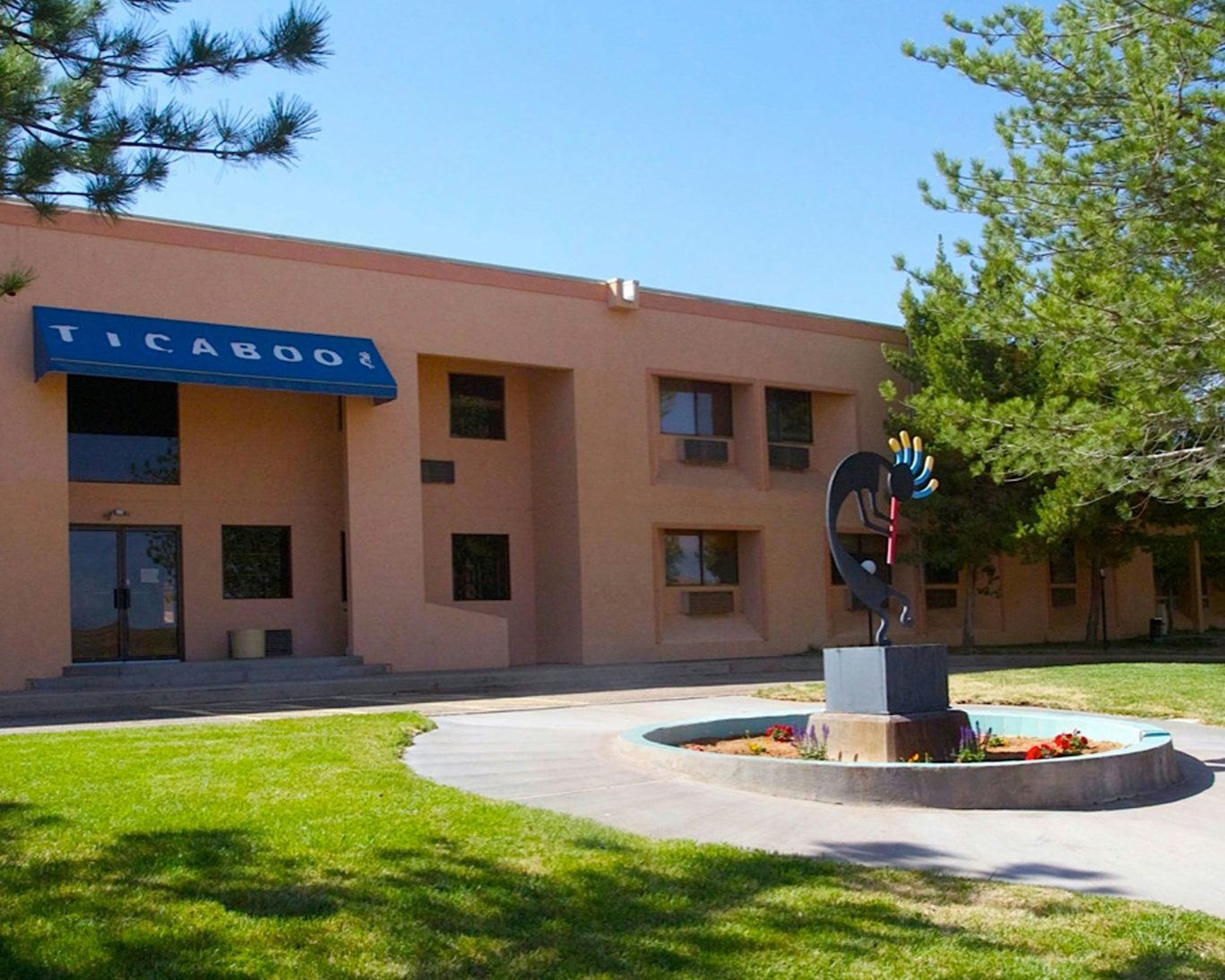 Front view of Ticaboo Lodge with southwestern architecture and courtyard sculpture.