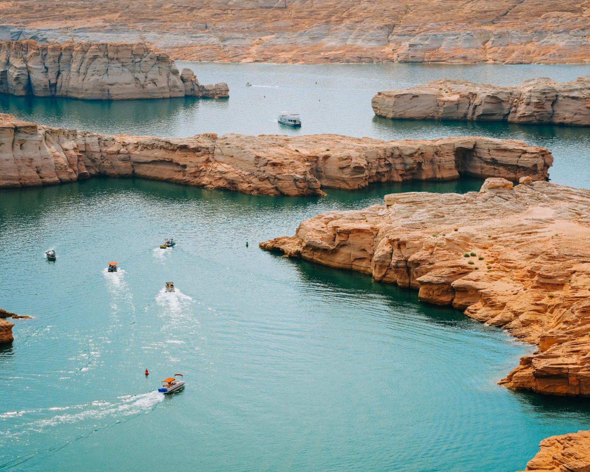 Boats cruising through the striking red rock formations at Bullfrog Marina on Lake Powell, Utah.