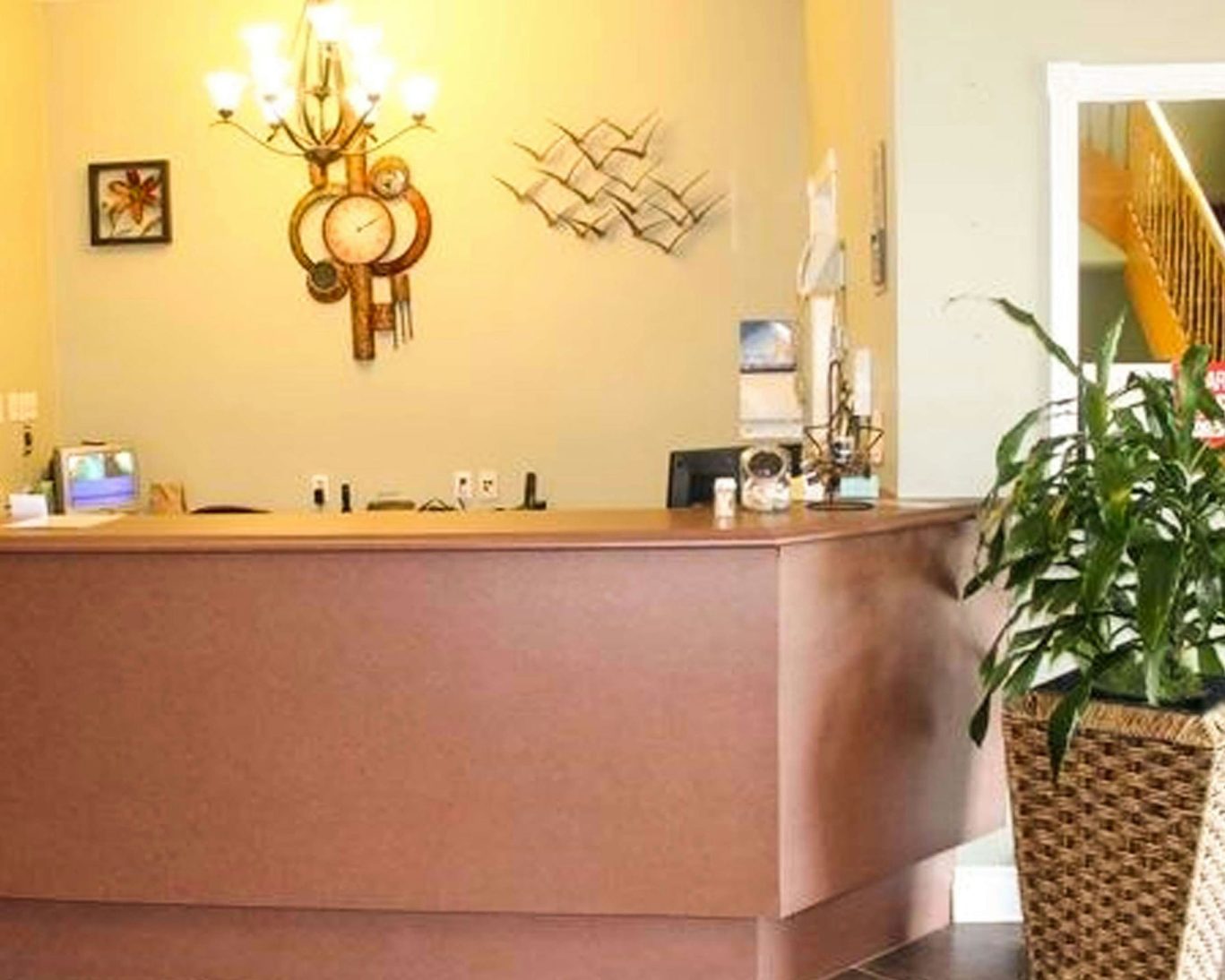 Front desk and reception area at Travellers Inn Summerside with decorative wall art and welcoming ambiance.