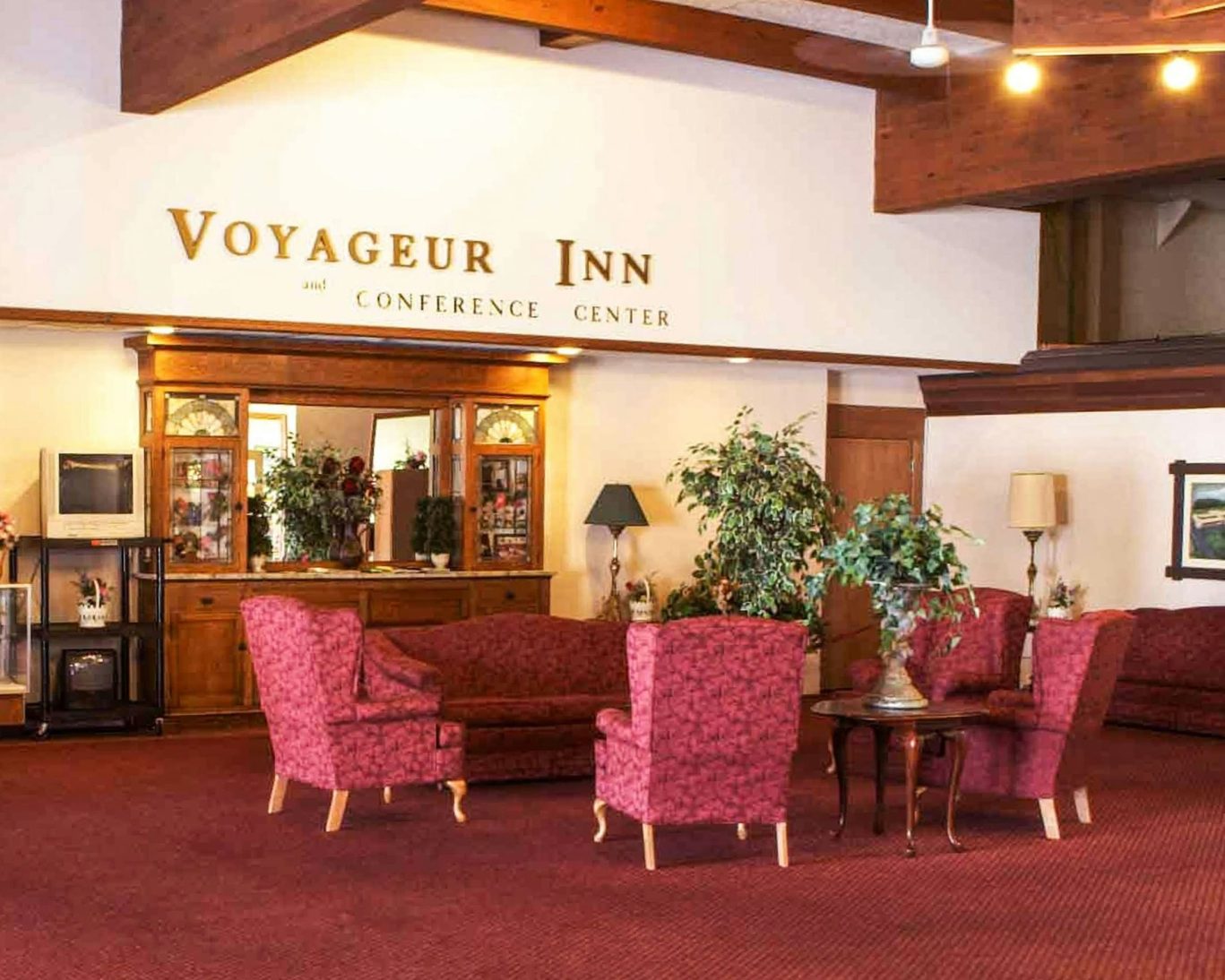 Spacious lobby at Voyageur Inn and Conference Center with elegant re.d seating and classic decor