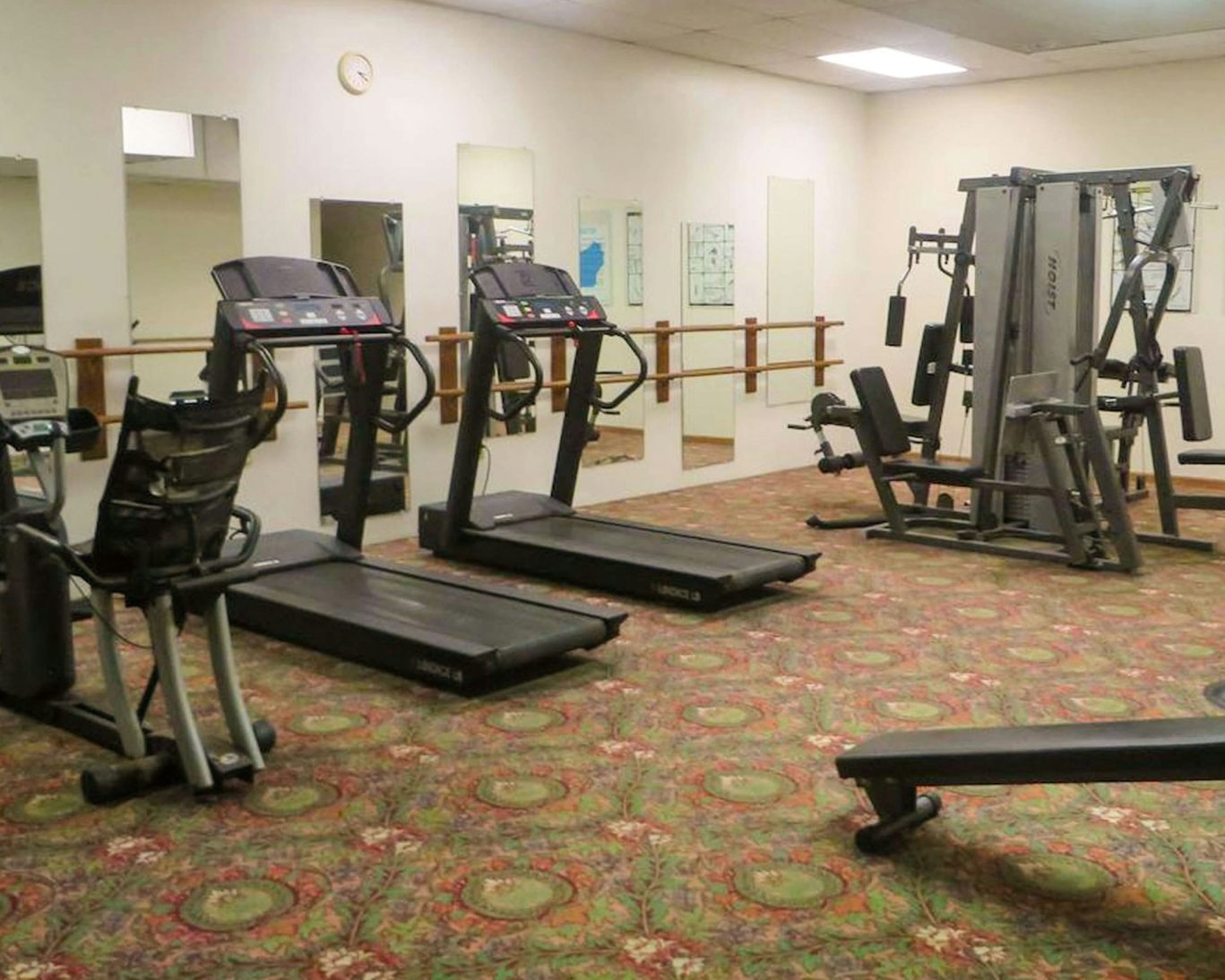 Fitness room at Voyageur Inn featuring treadmills, strength equipment, and mirrors.