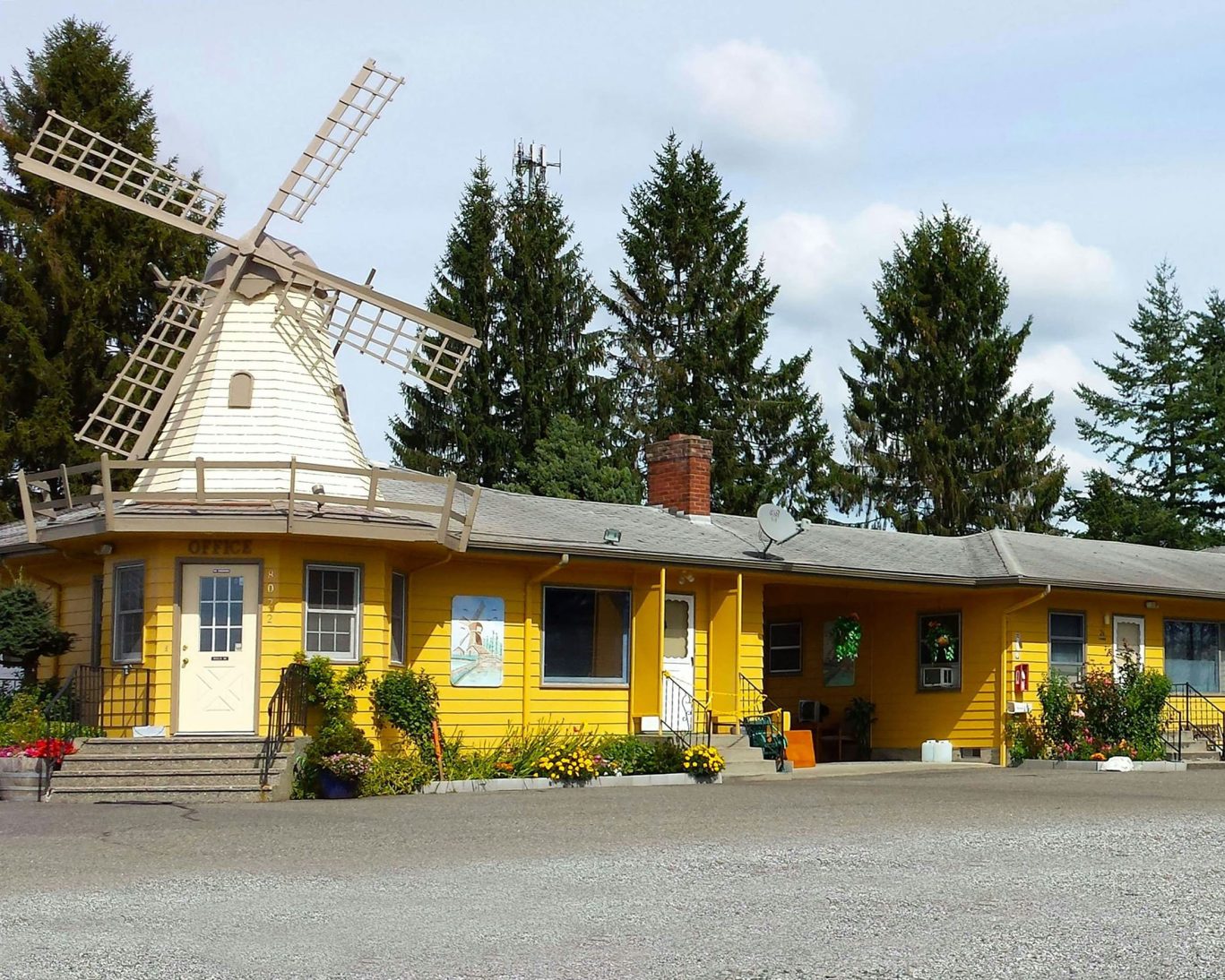 Yellow Windmill Inn motel with unique windmill feature and flower garden in Lynden, Washington.