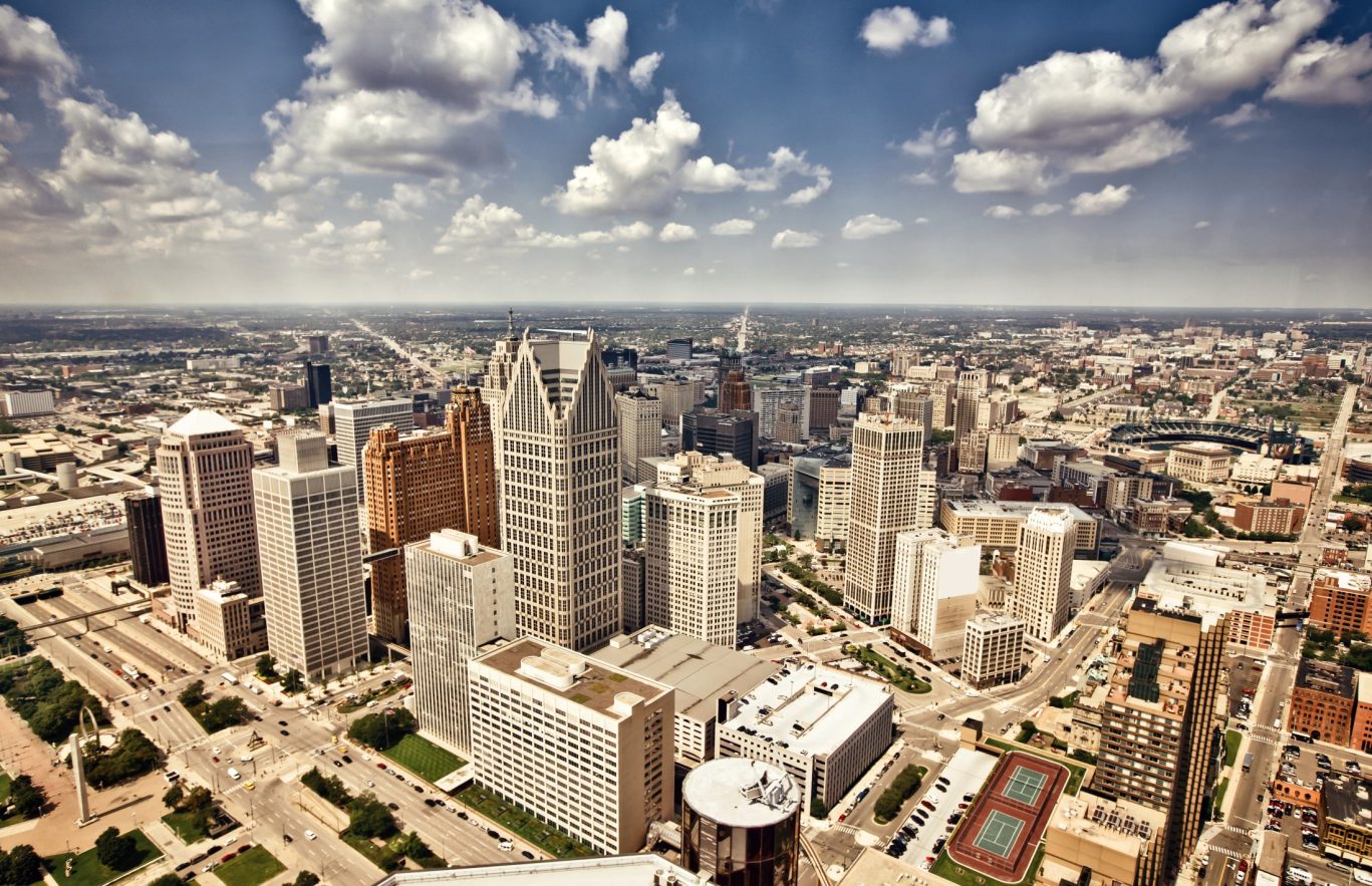 Aerial view of downtown Detroit skyline under partly cloudy skies, Michigan.
