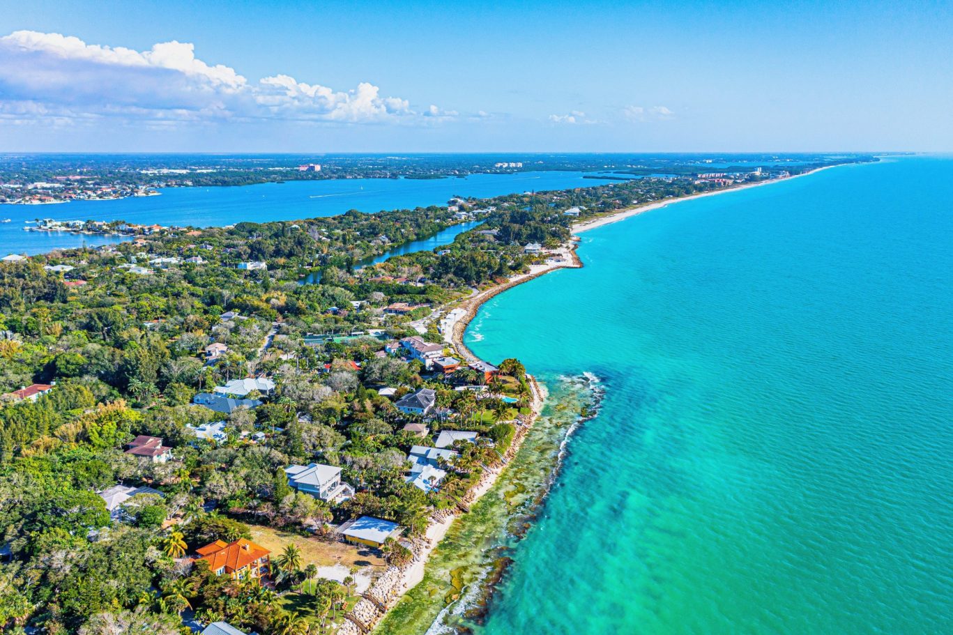 Aerial view of Florida Gulf Coast with beachfront homes and turquoise ocean.