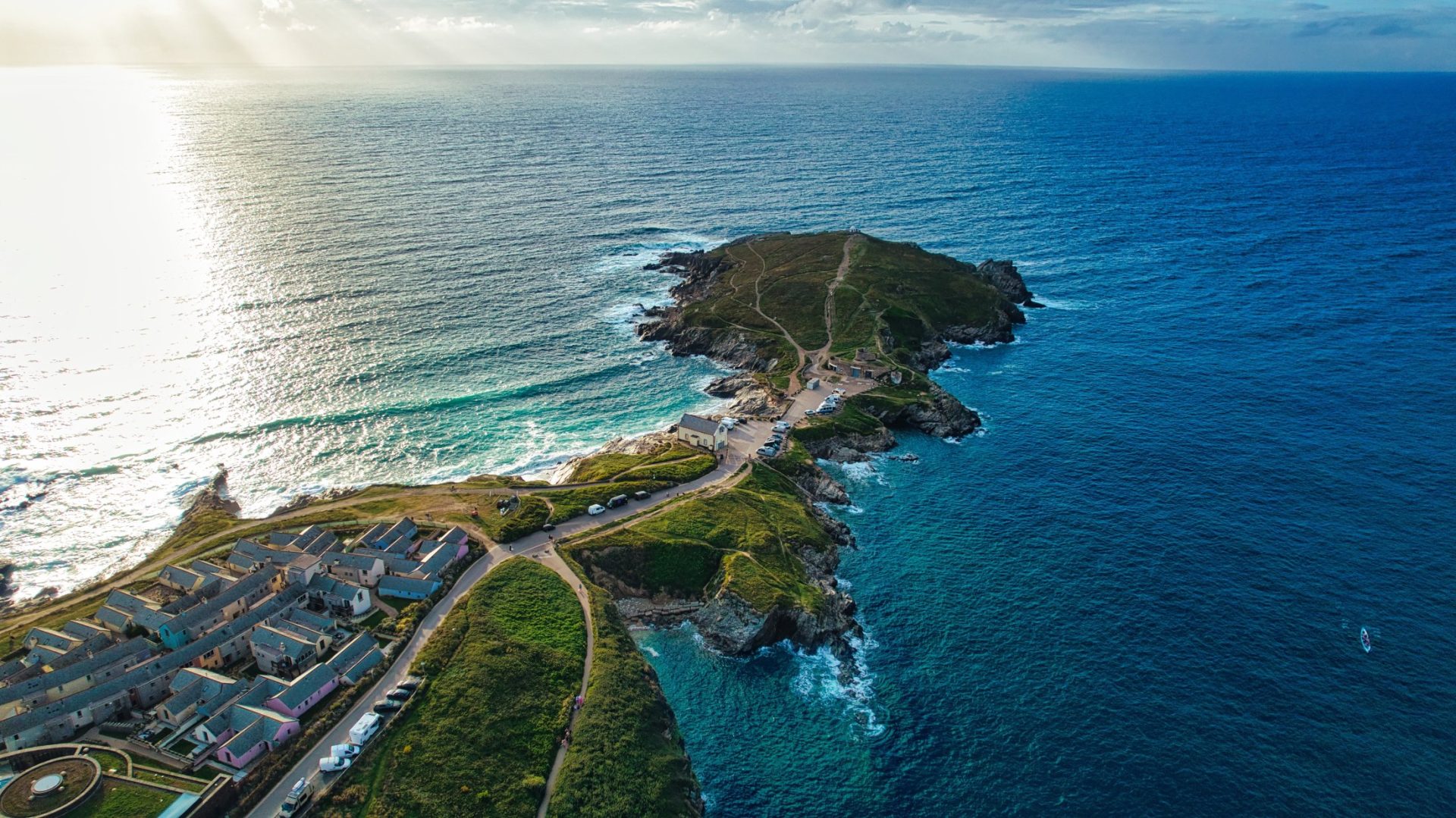 shutterstock_2526718825 – Aerial view of a coastal landscape featuring a peninsula extending into the ocean. At Fistral Beach, Newquay, Cornwall, UK
